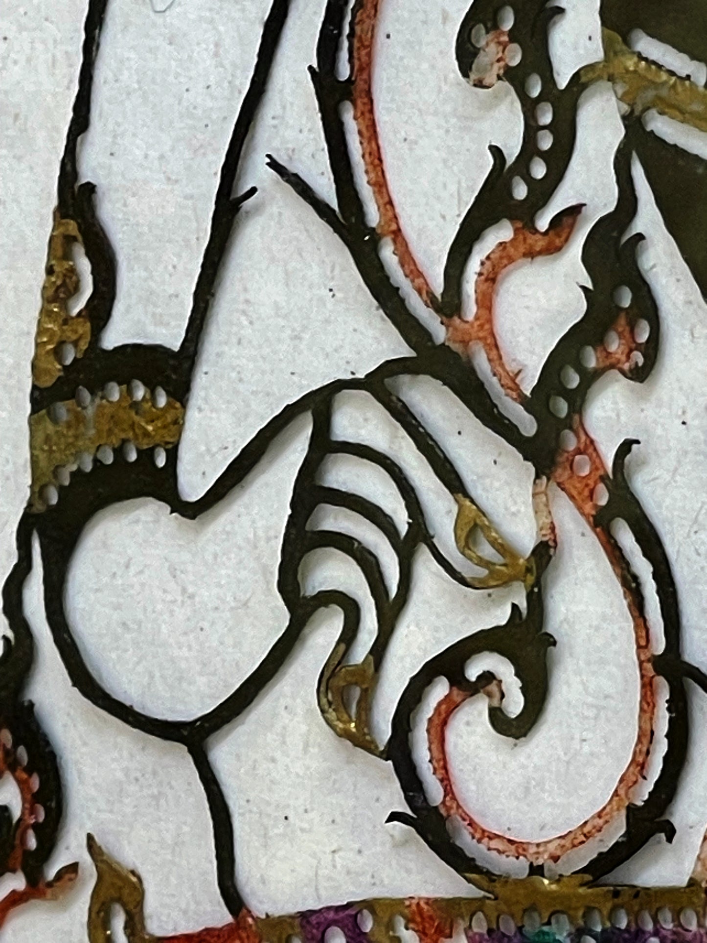 Filigree leather openwork detail showing the shadow-figure cutting technique