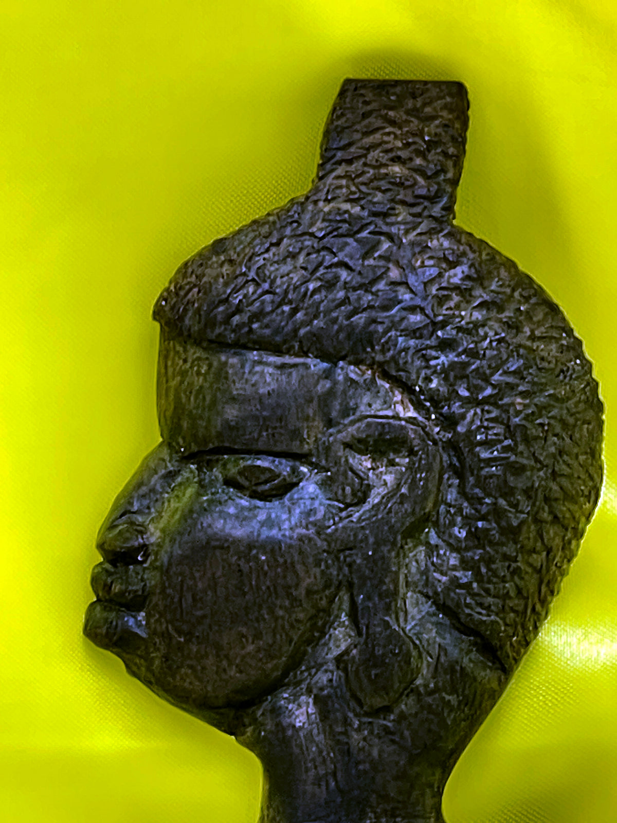 Close up of the finely carved woman's head with textured coiffure