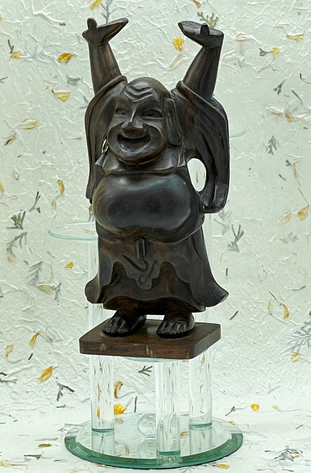 Hand carved ebony laughing Hotei Buddha with arms raised, angled full view