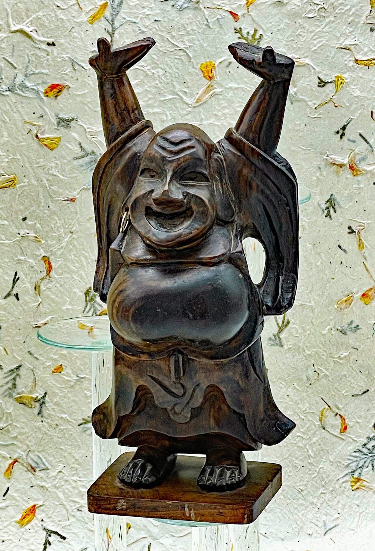 Front view of vintage ebony Happy Buddha showing laughing face and brass earring