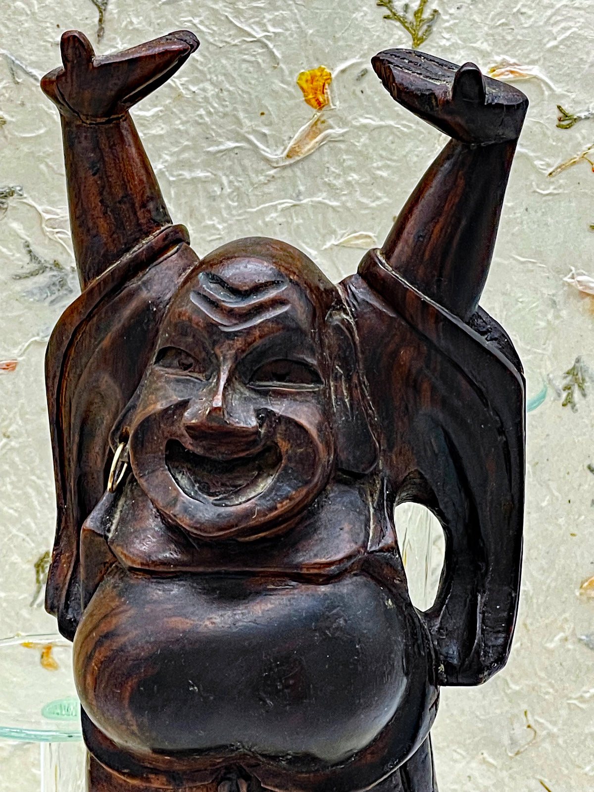 Side view of the vintage ebony Hotei Buddha statue showing robe carving