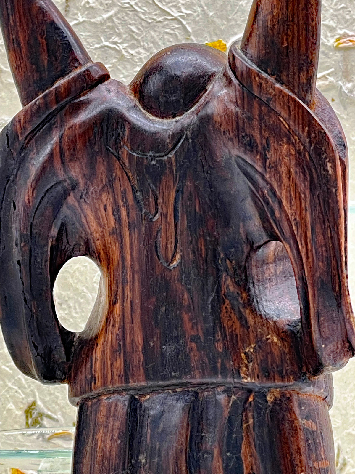 Angled view of the vintage ebony Happy Buddha statue with arms raised