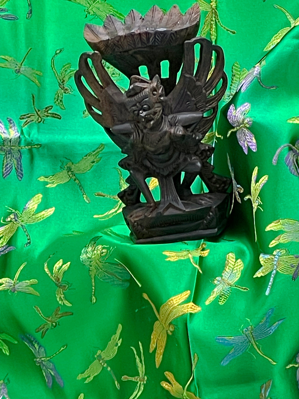 Angled full view of the antique flying Garuda carving showing fierce face and crest