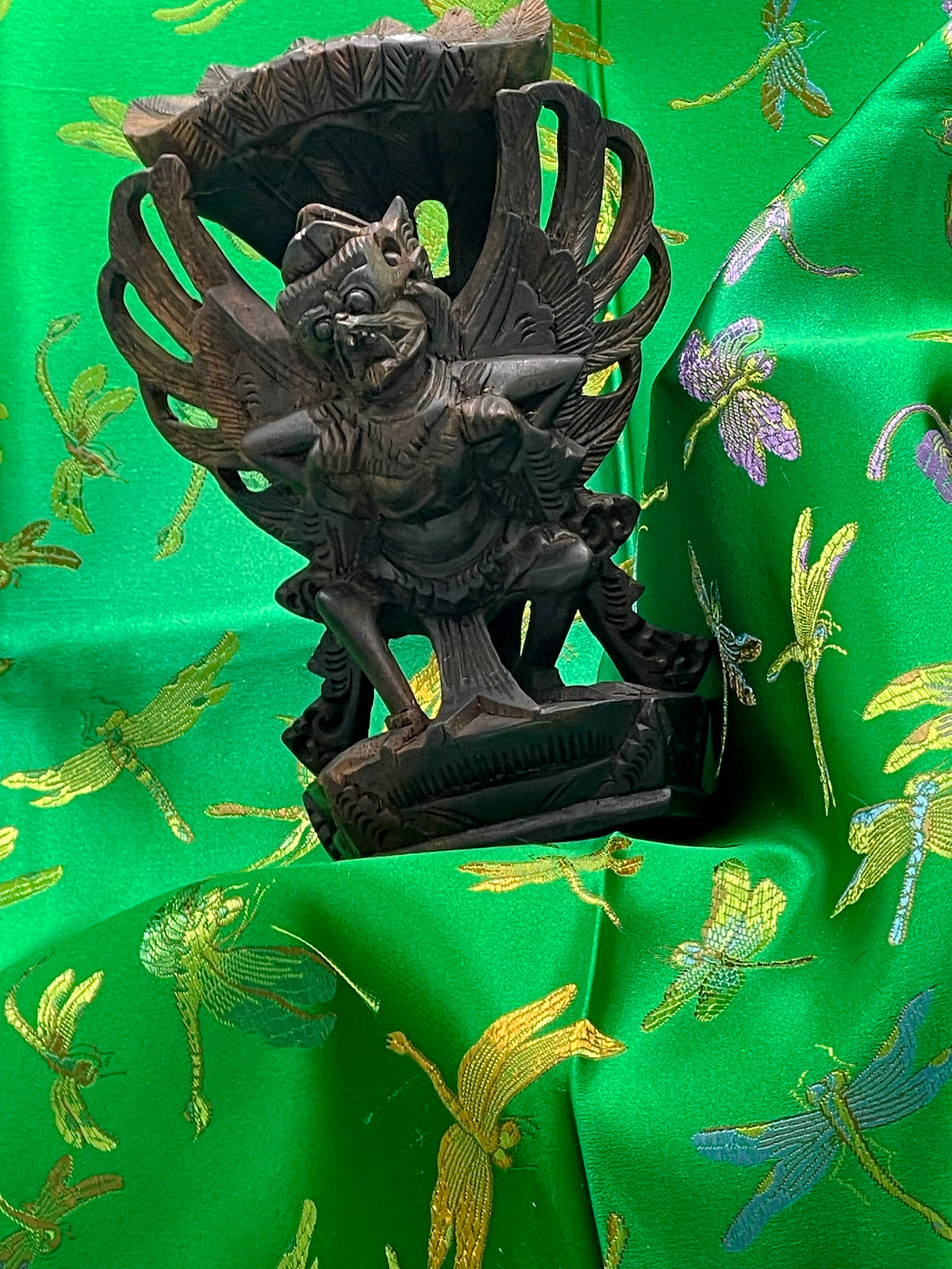 Angled view of the antique ebony Garuda showing carved base and legs