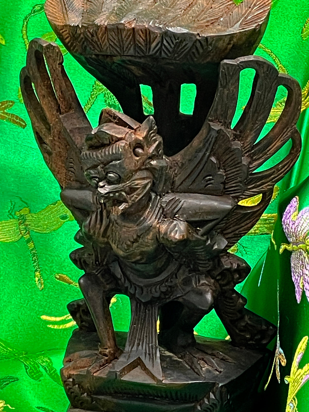 Close up detail of the Garuda face, beak and crosshatched feather carving