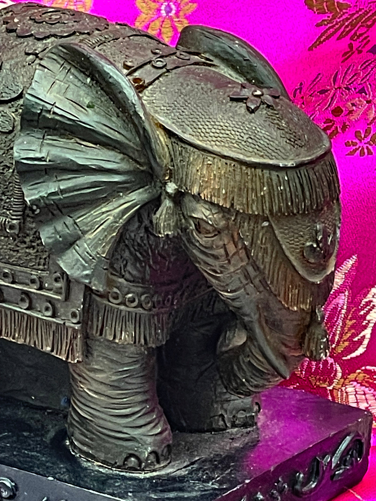Detail of elephant head with fringed cap, fanned ear and floral medallion