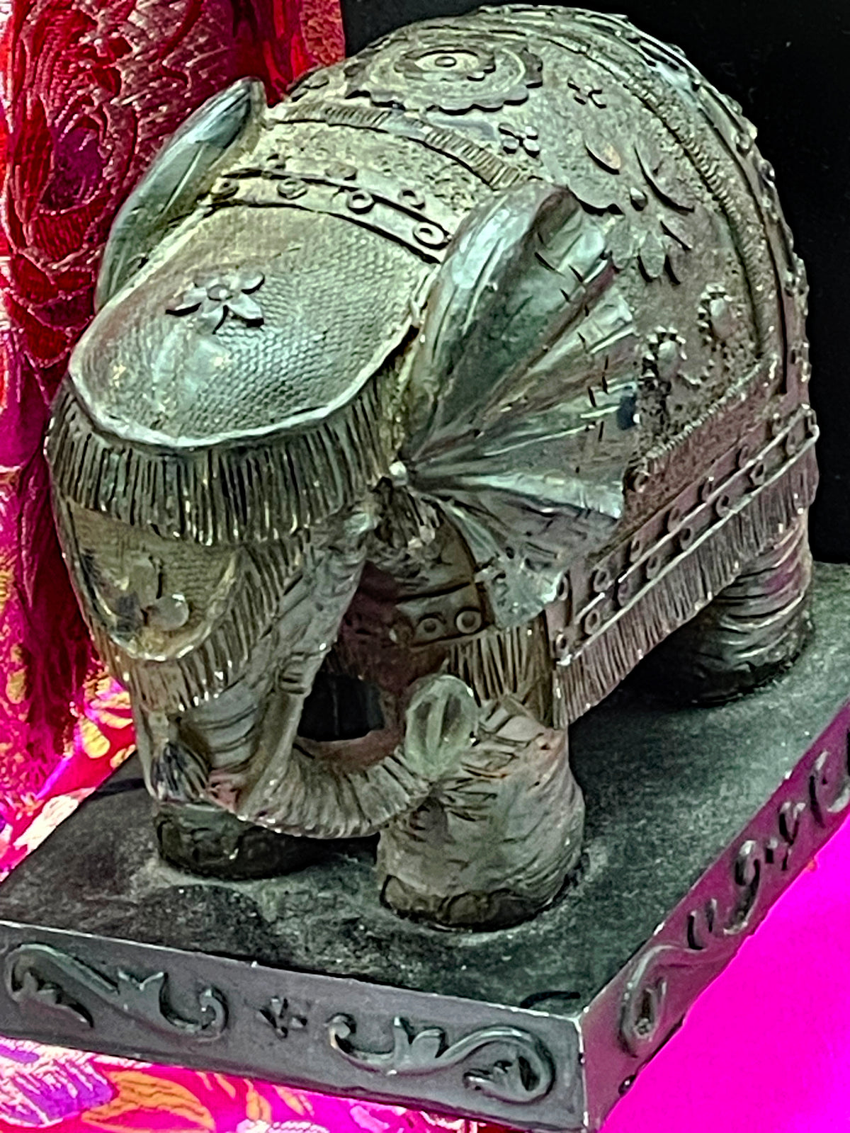 Three quarter view of elephant bookend with curled trunk and studded caparison