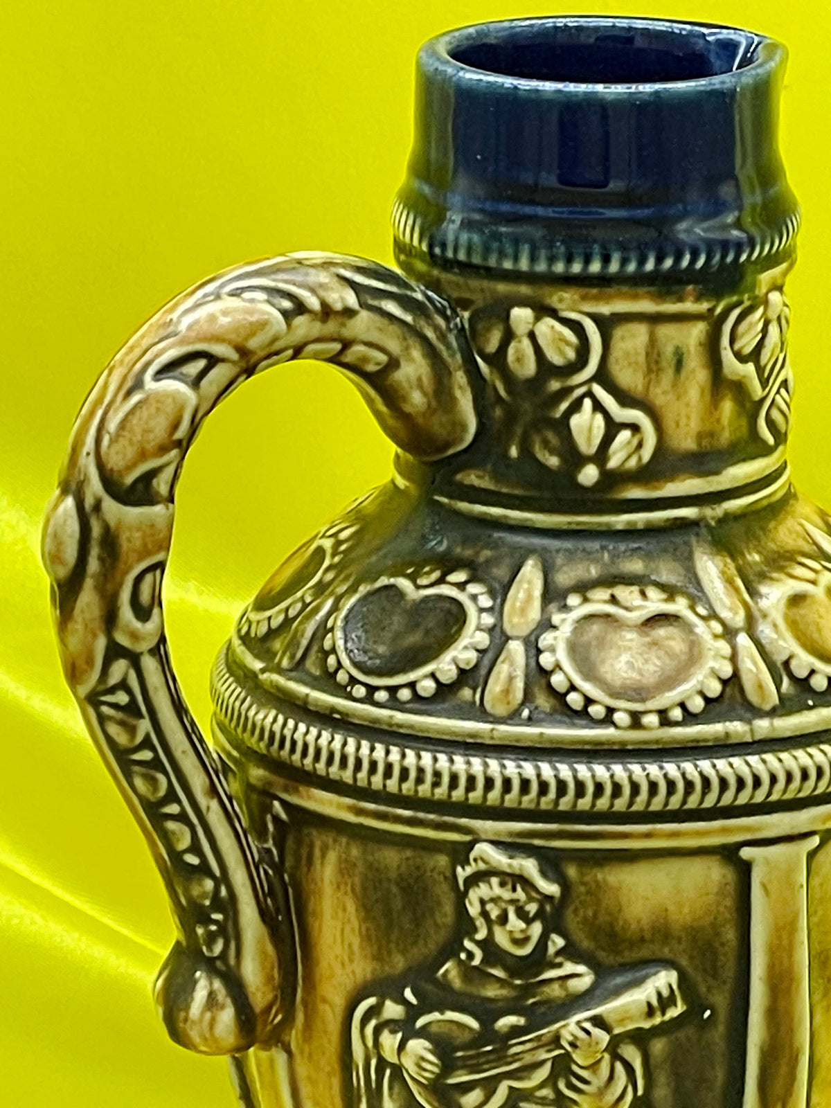 Detail of neck, floral frieze and scrolled handle of vintage German relief jug