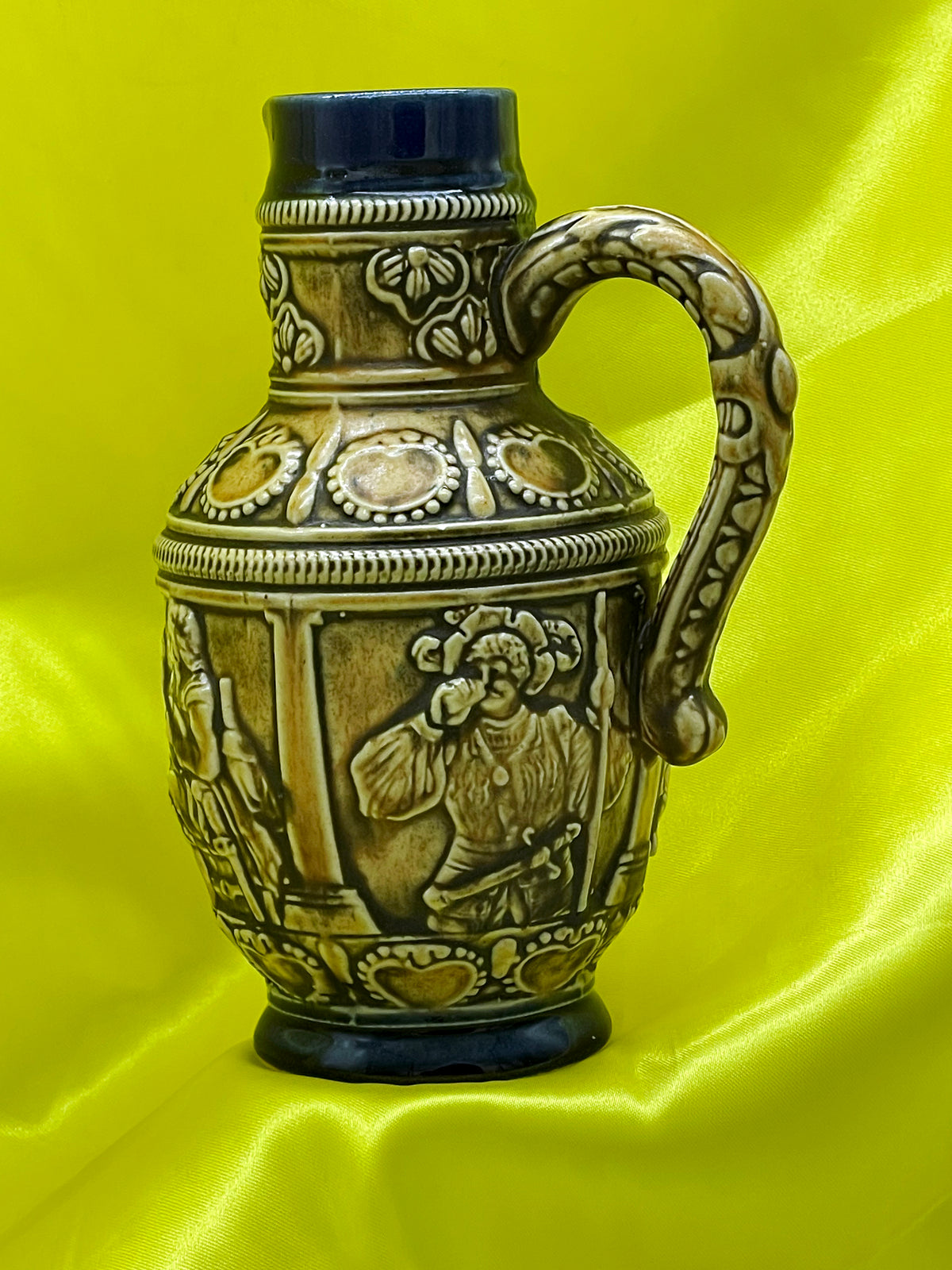 Back view of vintage West German jug showing drinking figure and ornate scrolled handle