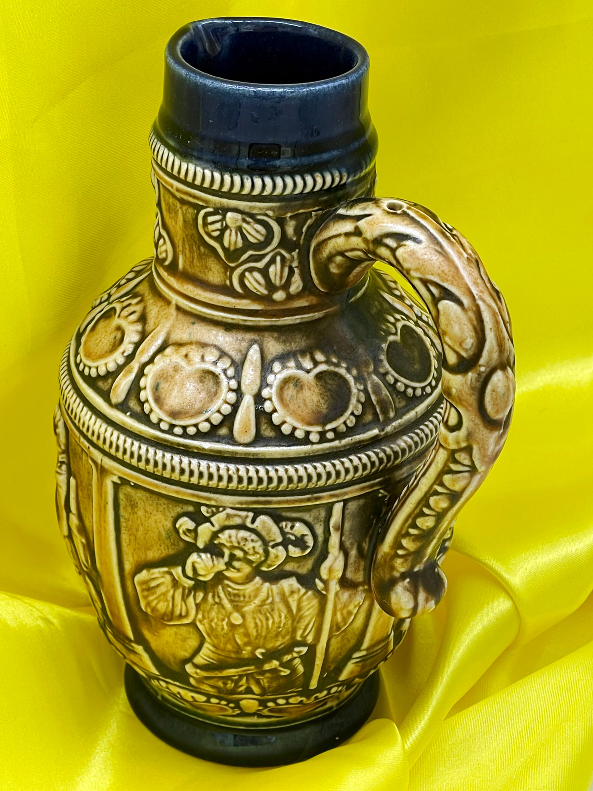 Angled view of vintage German ceramic jug with acanthus relief handle and cobalt neck