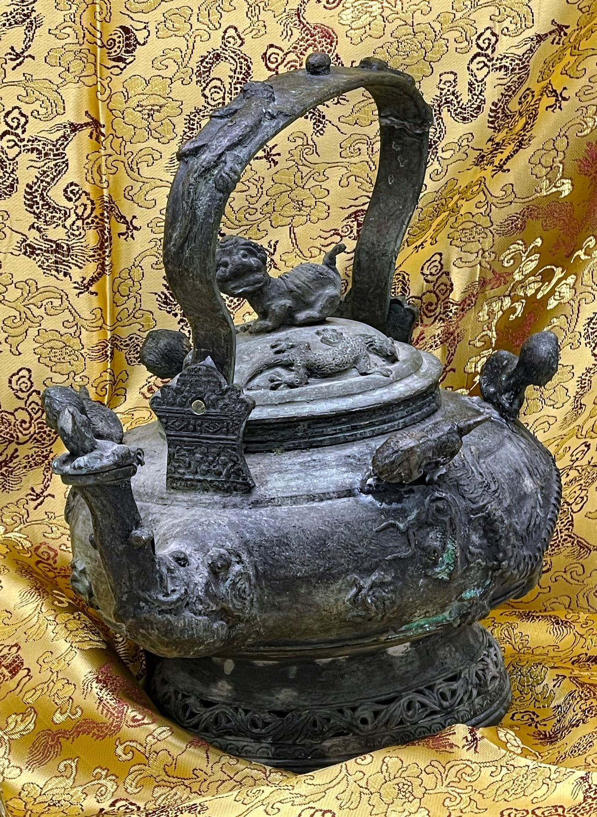 Detail of the richly decorated bronze body with mythical figures and verdigris patina