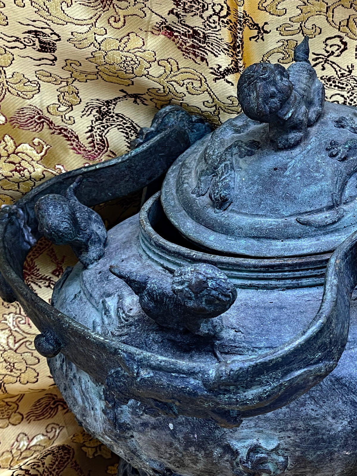 Close view of the removable lid and mythical beast appliques on the bronze body