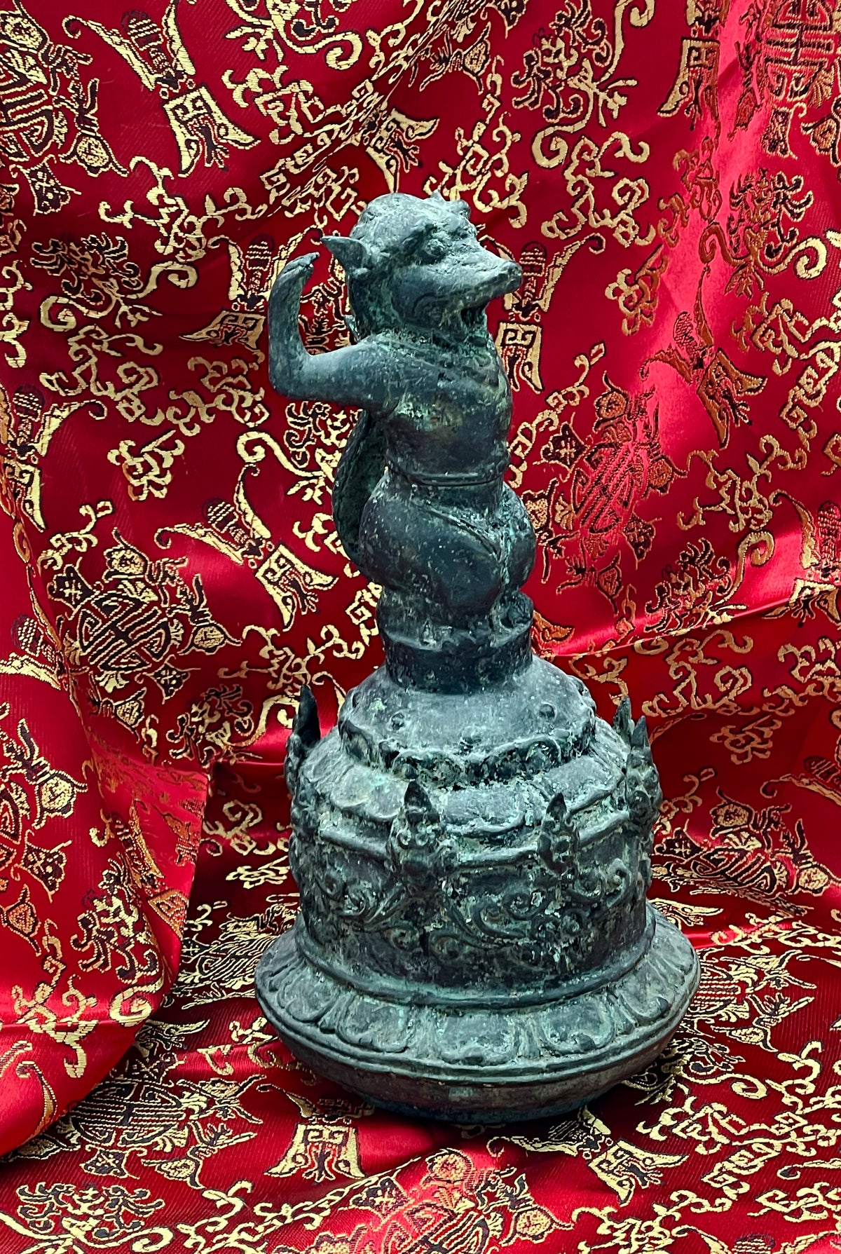 Full view of antique Chinese ritual bronze bell with guardian figure and verdigris patina