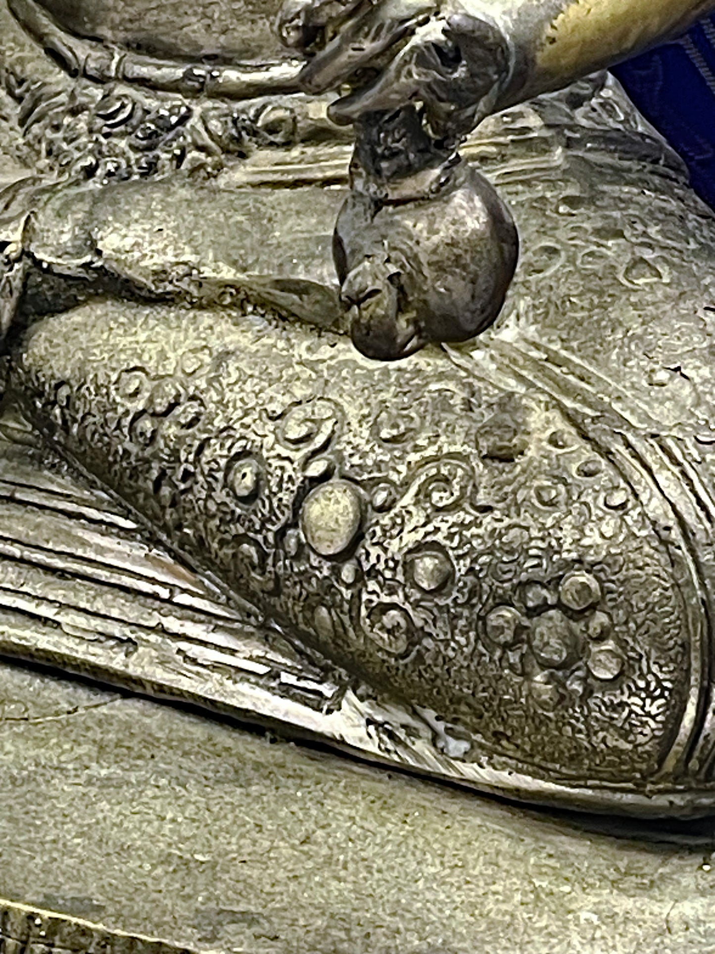 Close up of finely engraved garment and patina on the seated bronze Vishnu