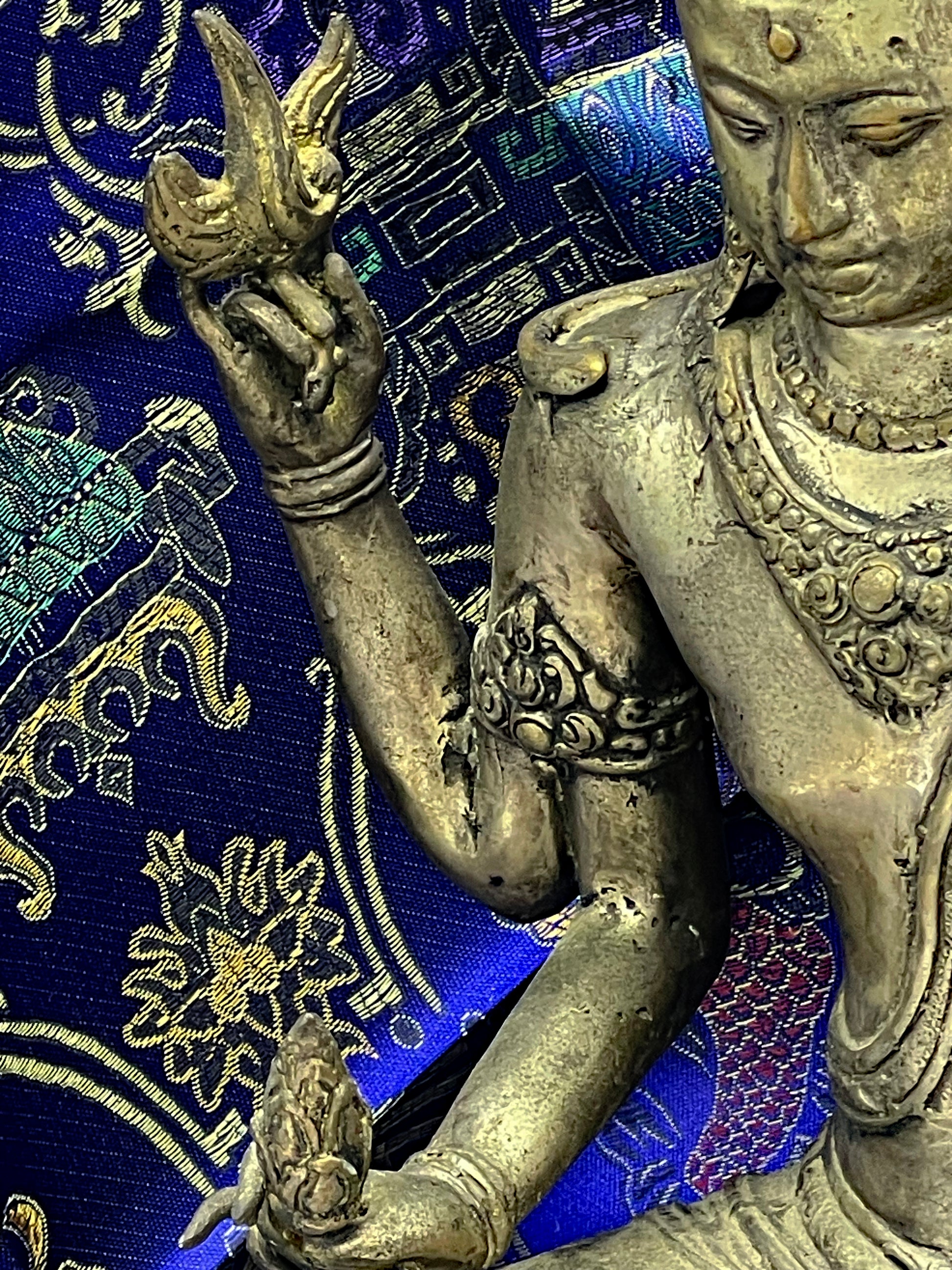 Detail of Vishnu raised hand and arm with bracelets and floral attribute