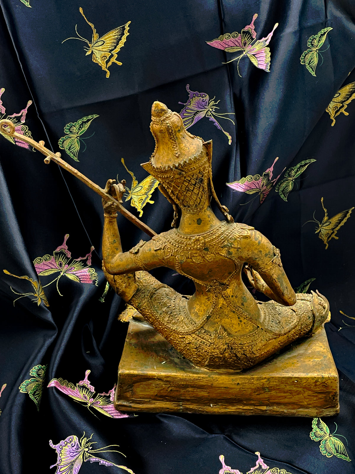 Back view of the antique Thailand gilded bronze Saraswati statue with ornate court dress