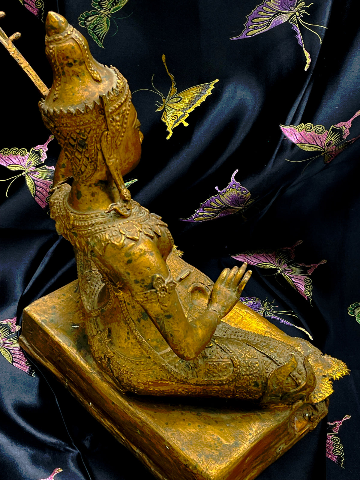Side profile of the antique Thai gilded bronze Saraswati statue showing crown and instrument