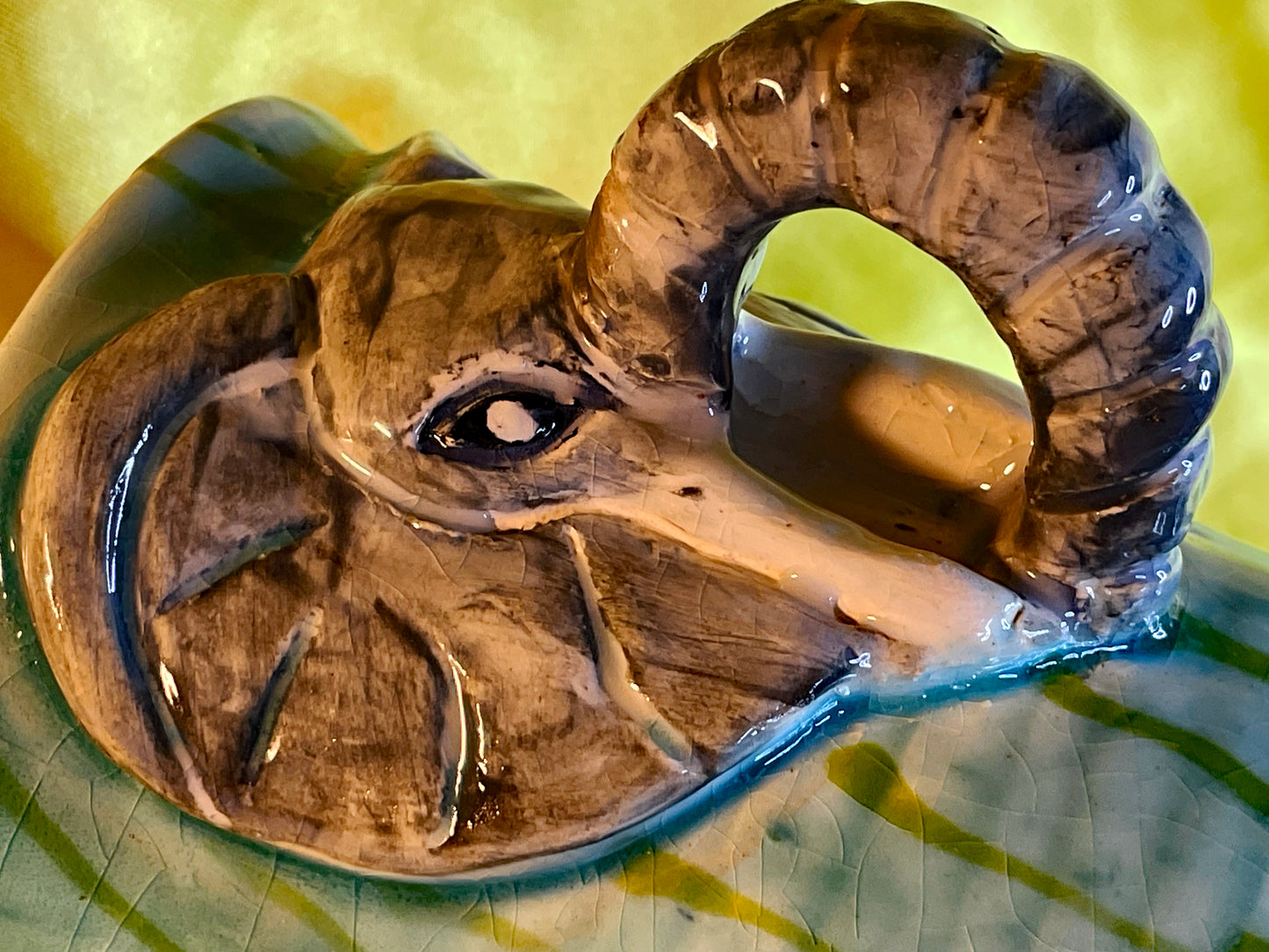 Detail of the elephant trunk forming the loop handle against the green and turquoise glaze