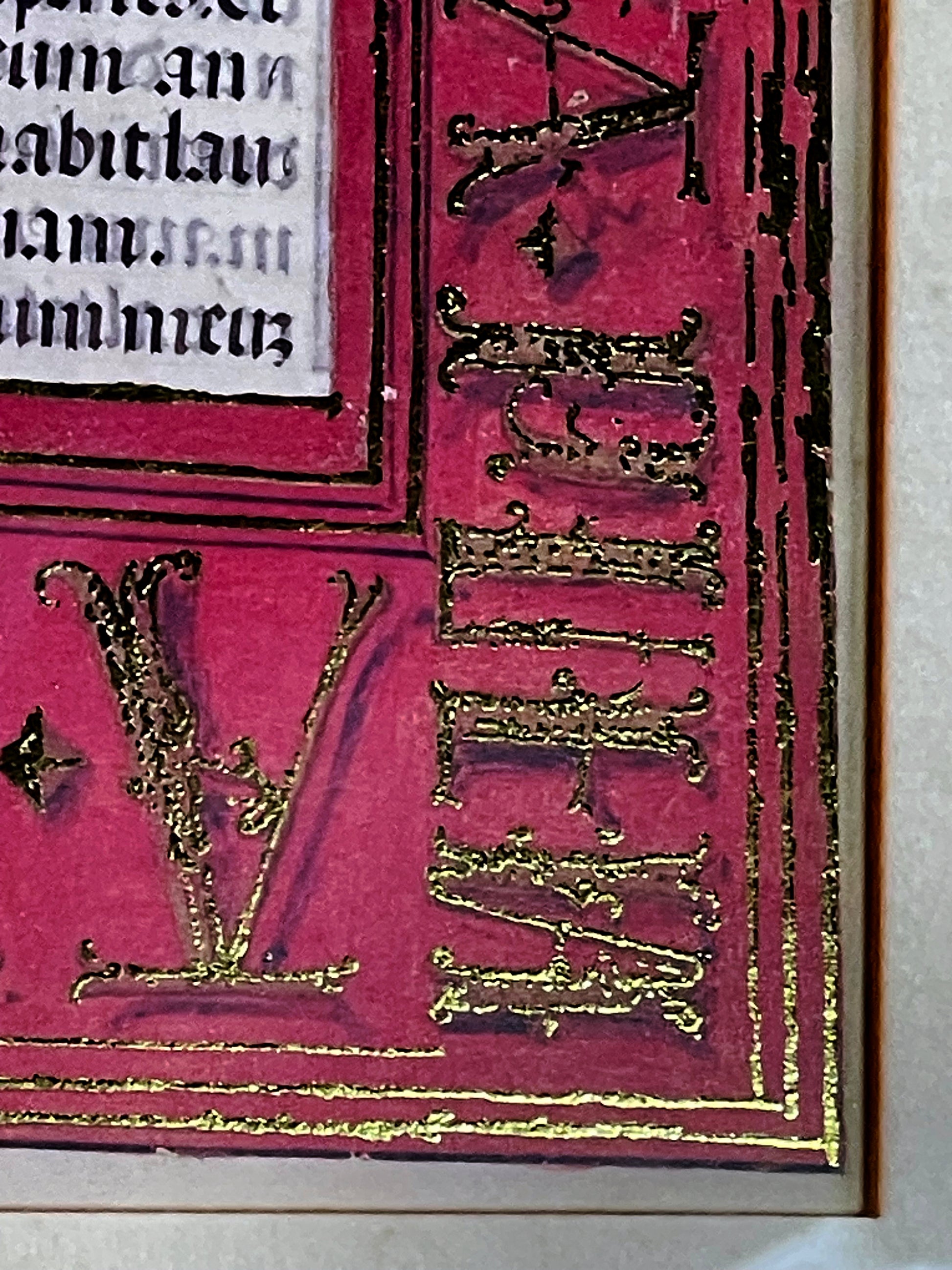 Close up of gold embossed Gothic lettering and red ground on an illuminated manuscript leaf