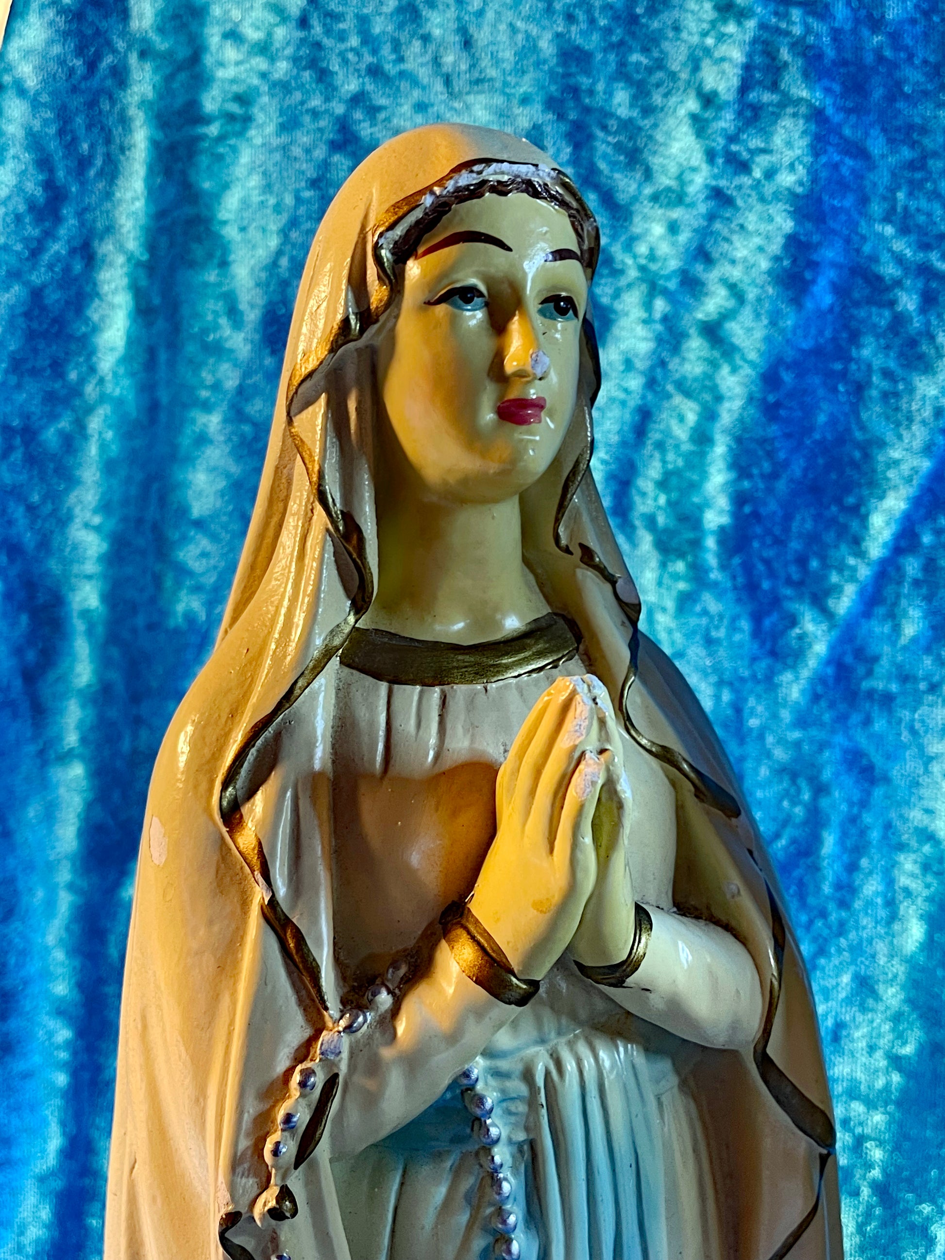 Our Lady of Lourdes plaster figure, face and praying hands with rosary detail
