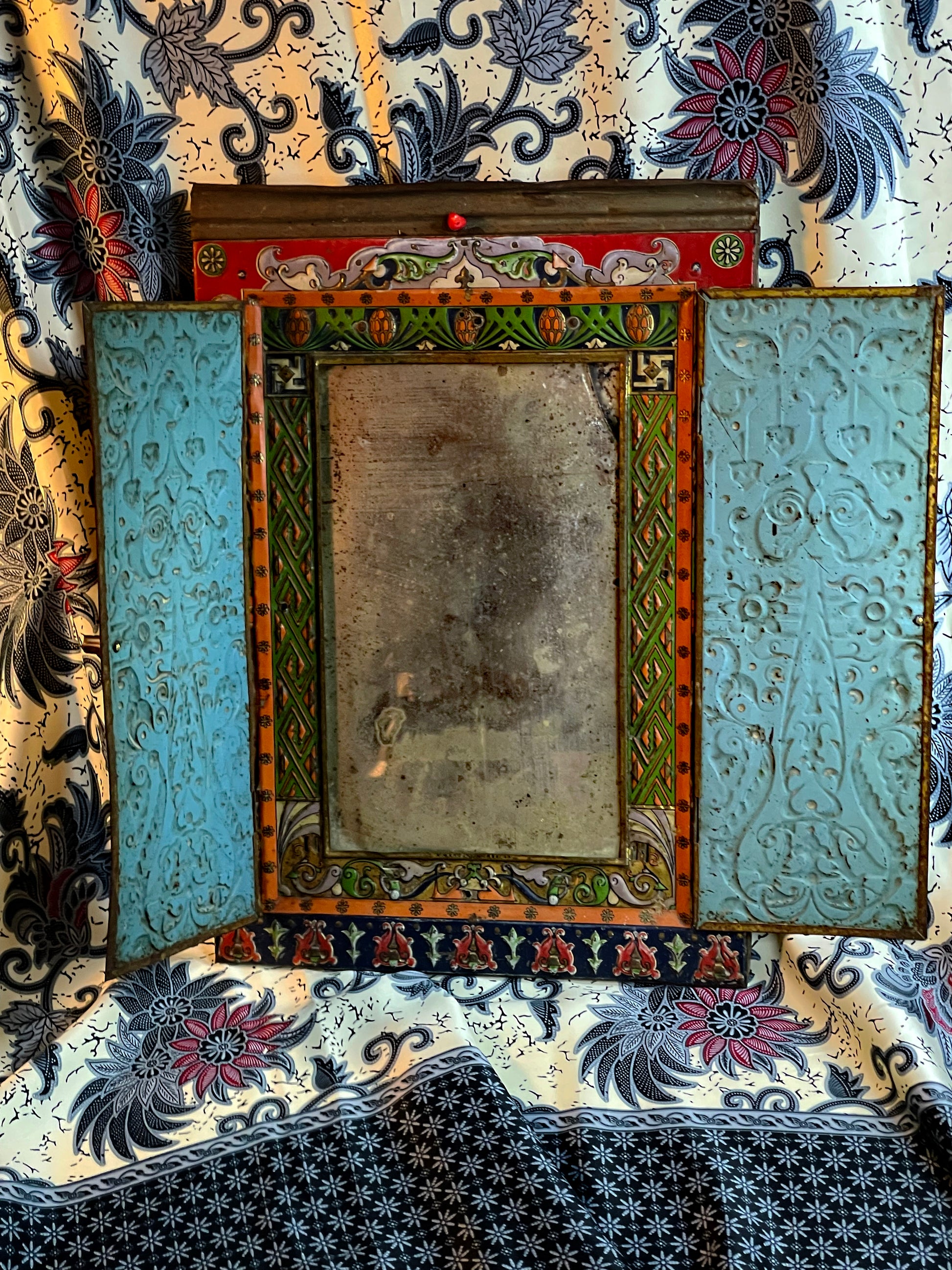 Antique Persian hand-painted folding mirror open, showing patinated mirror plate and painted frame