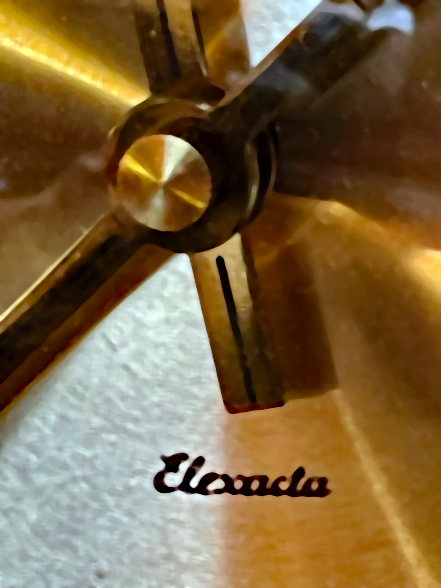 Macro detail of the Elexacta signature and brass hands on the dial