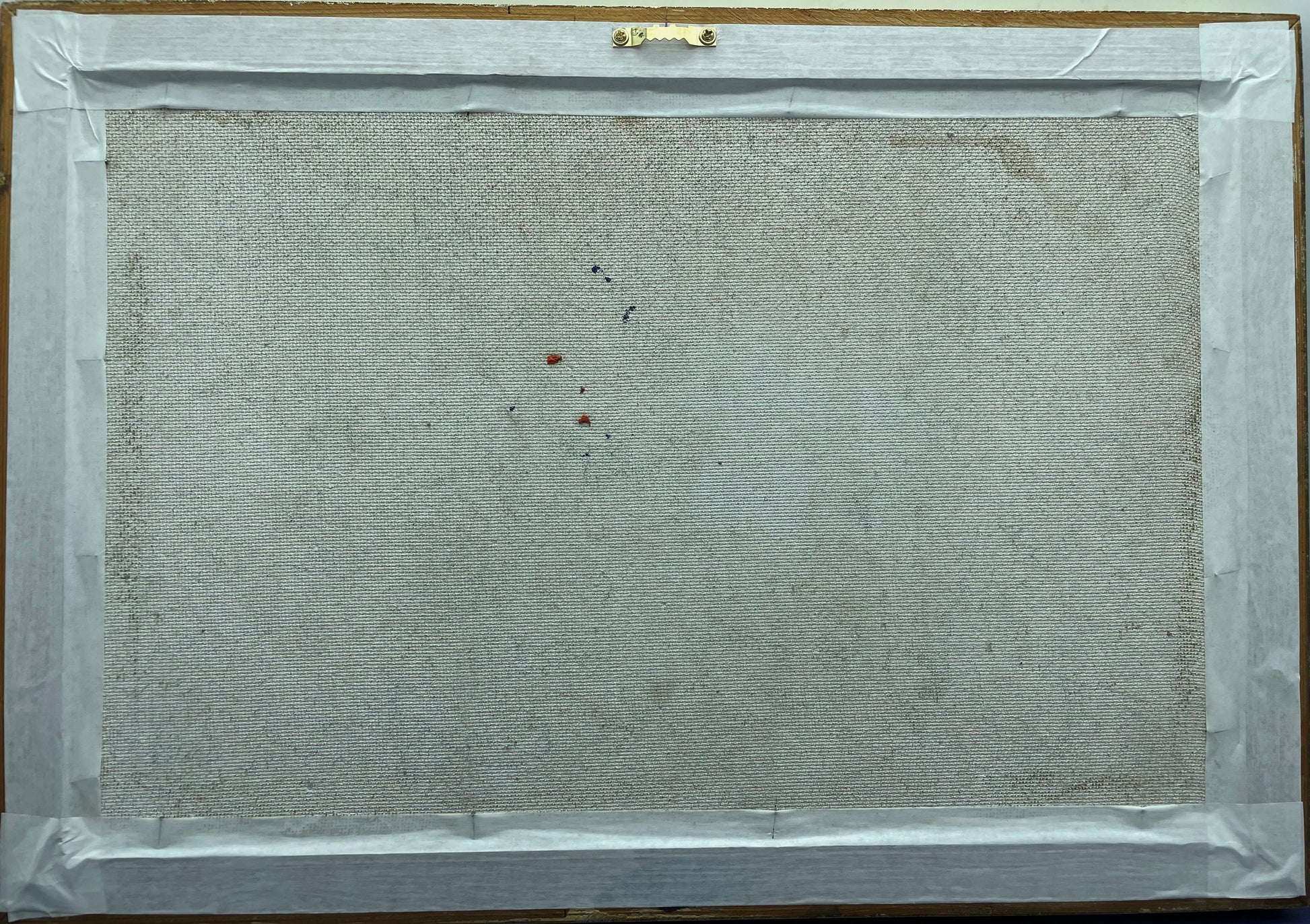 Reverse of the framed painting showing the canvas-backed board and hanging fitting