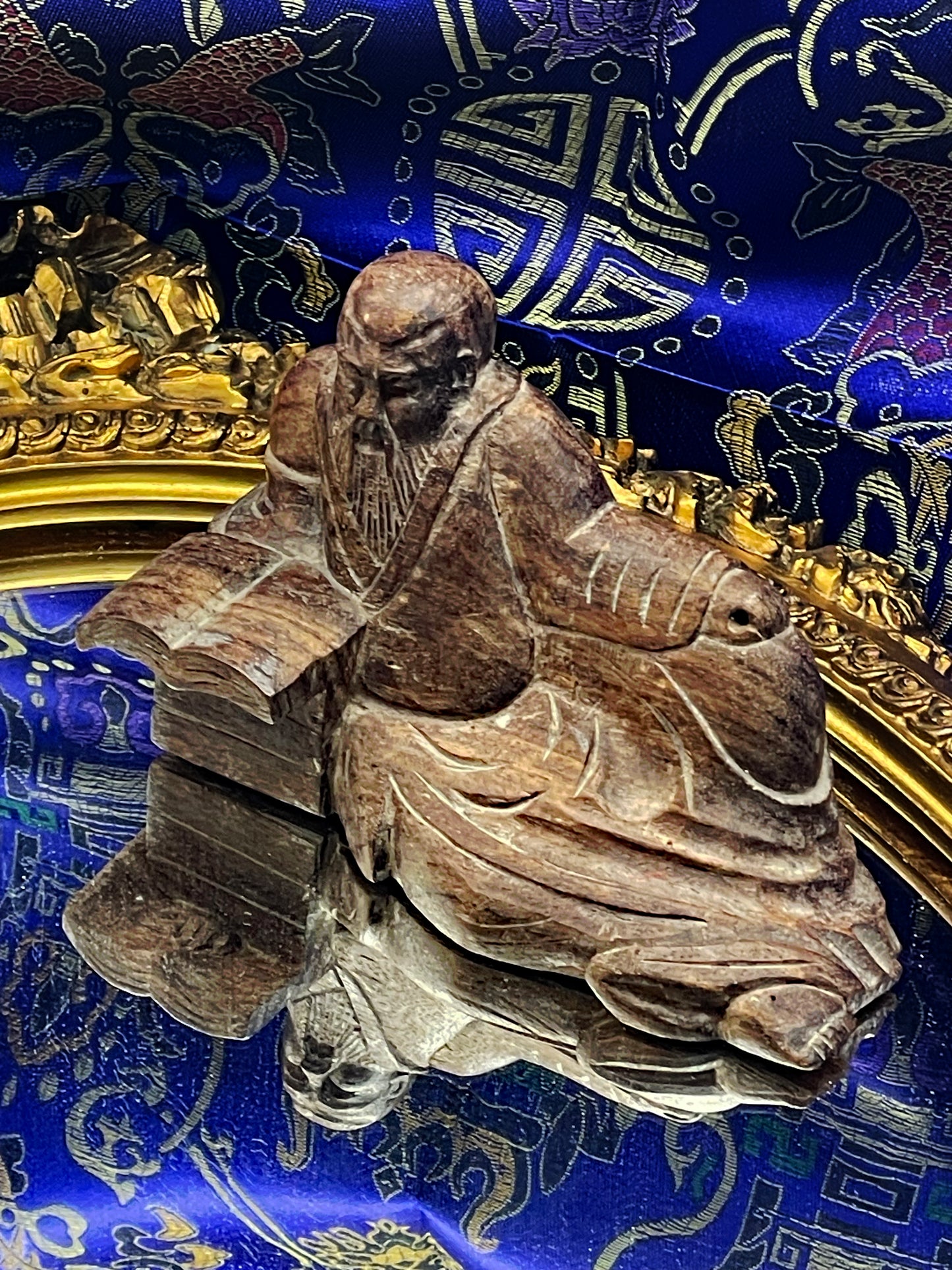 Close-up of the hand-carved Confucius face and flowing hardwood robes