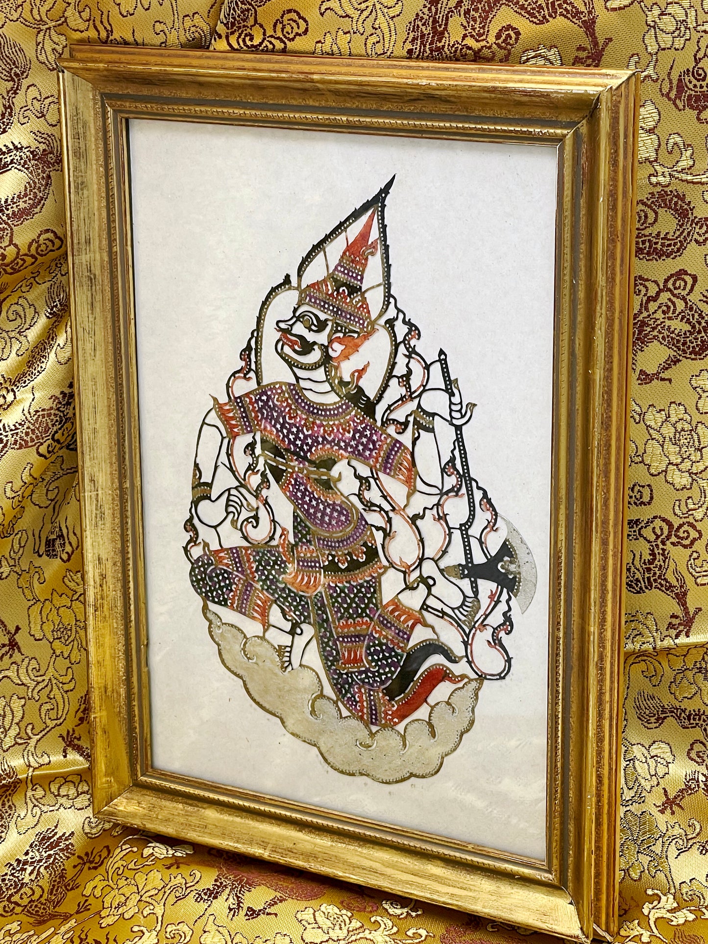 Close view of the hand-coloured leather deity figure within its gilded frame