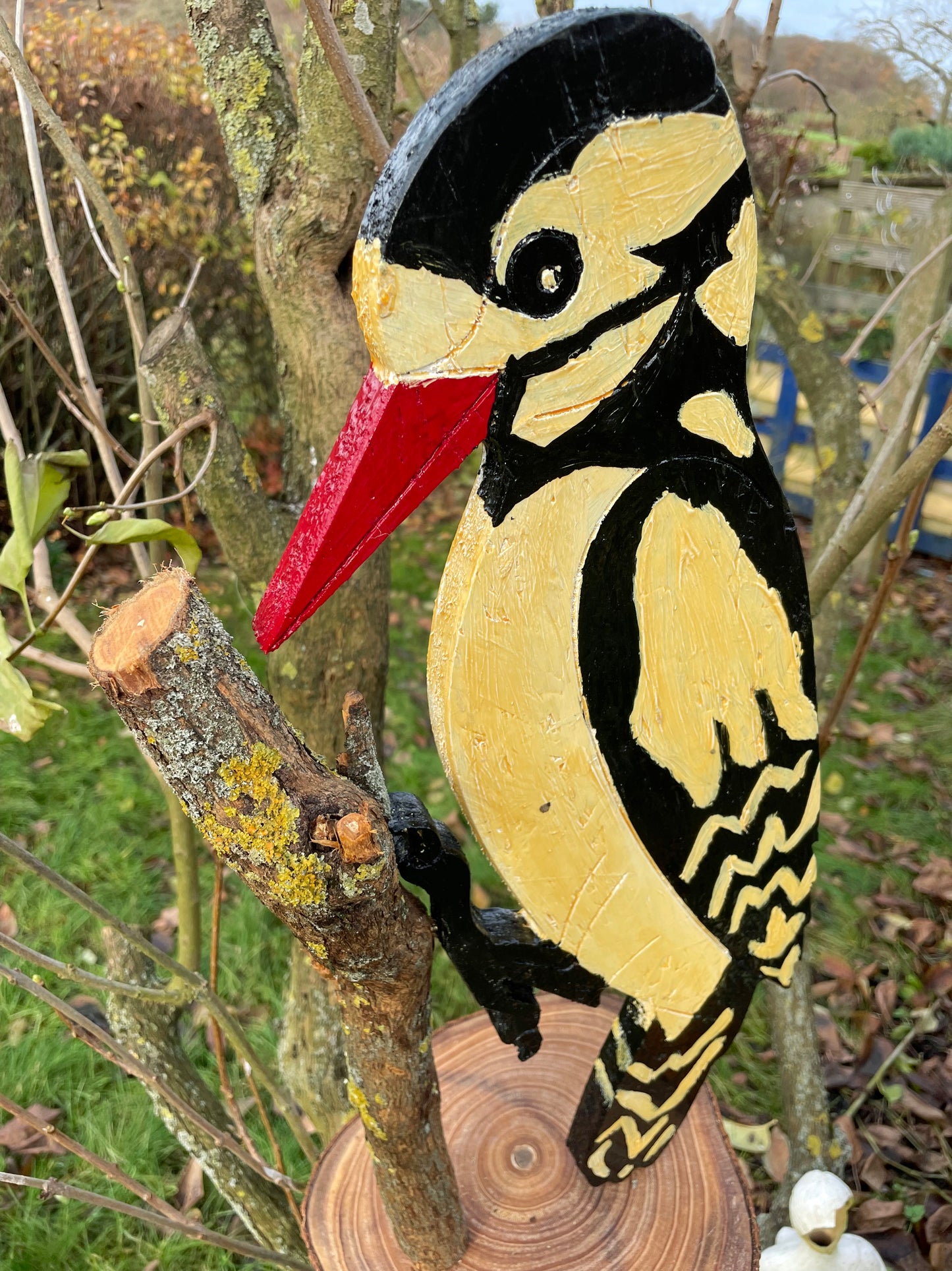 Close-up of painted plumage and brushwork on the wooden woodpecker sculpture