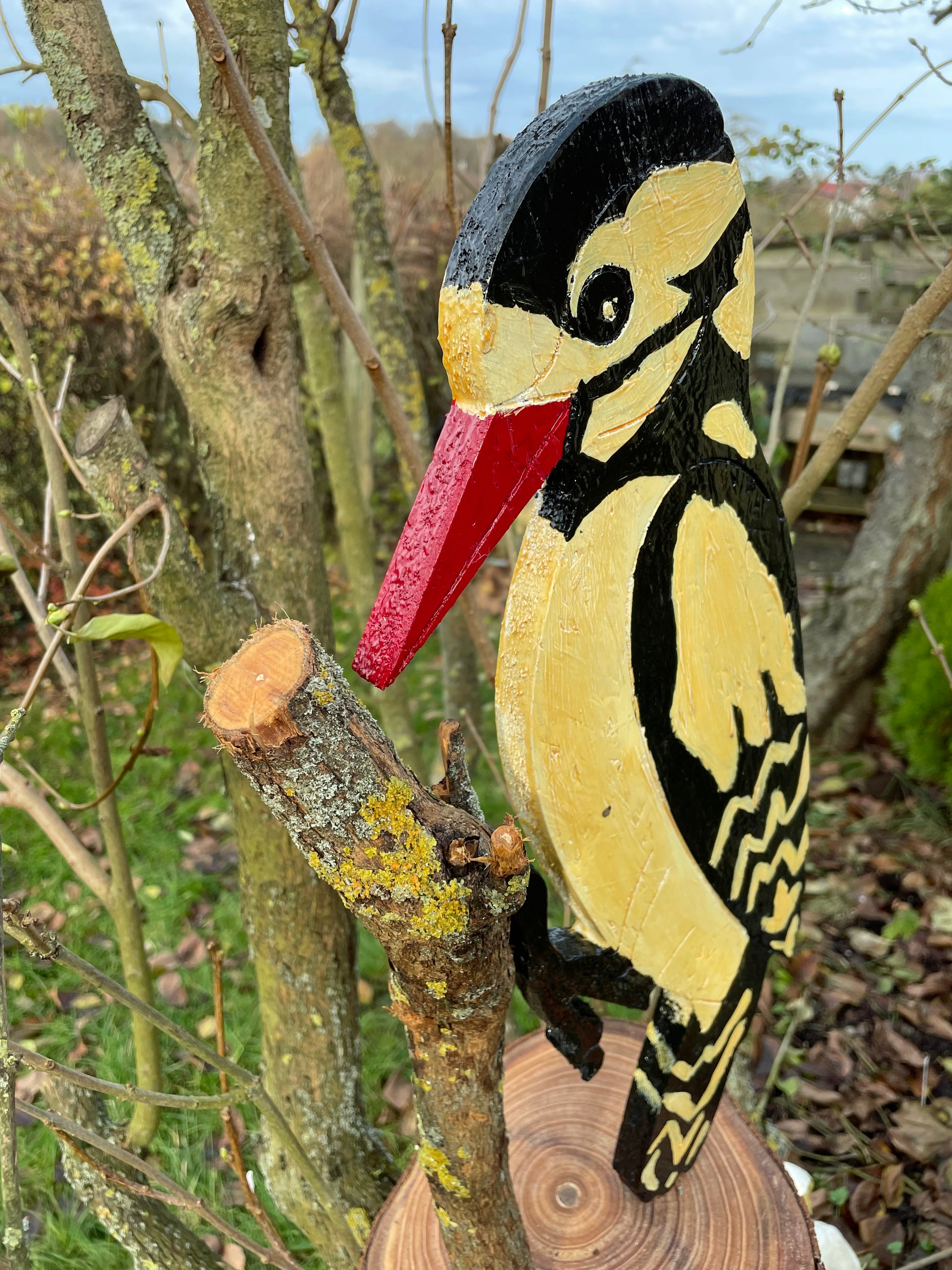 Underside view of carved woodpecker head and pointed red beak