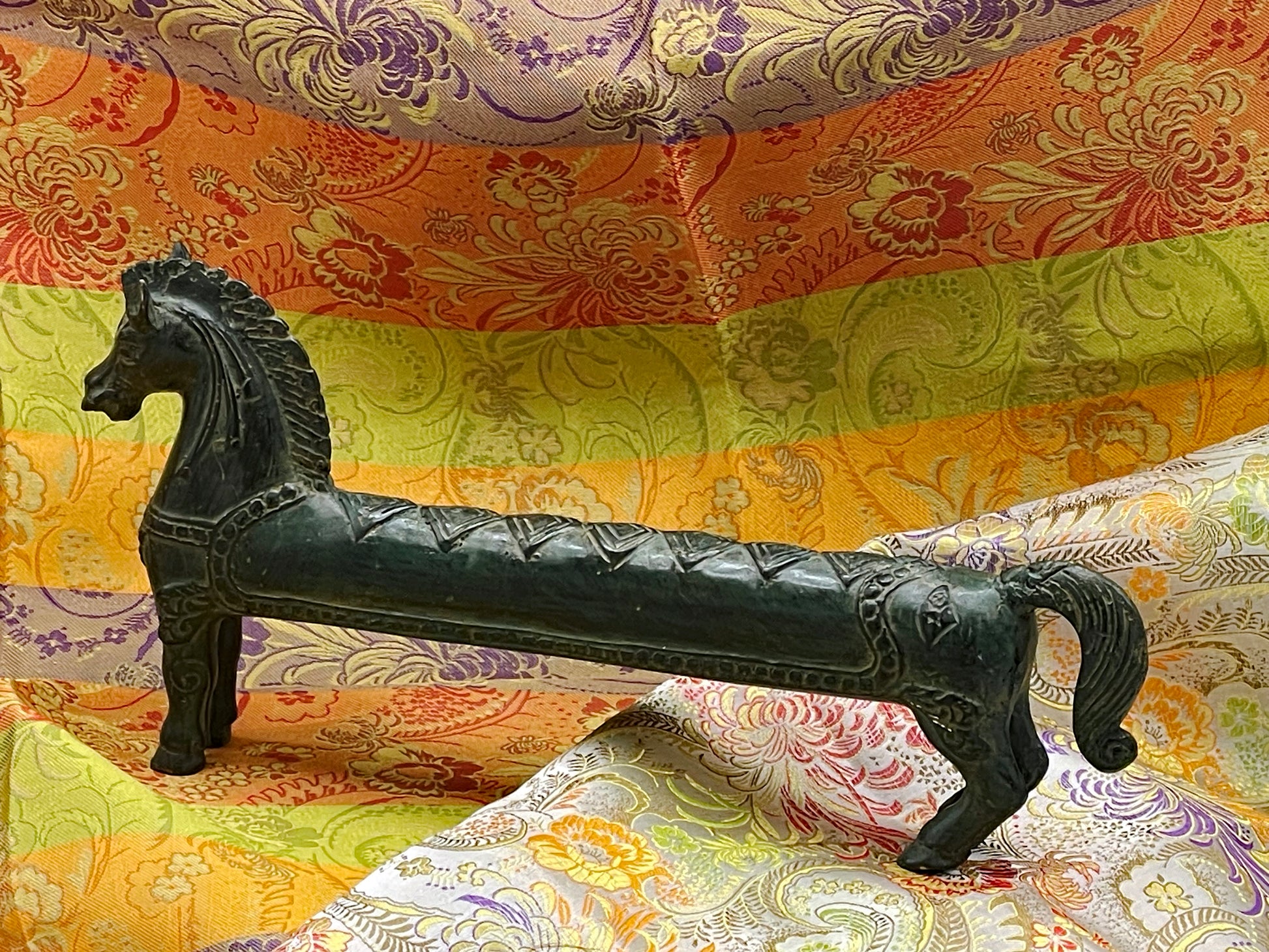 Elongated Indonesian bronze horse in full side profile showing green verdigris patina