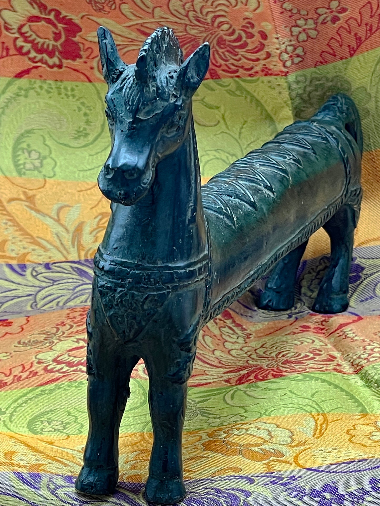 Front three-quarter full-body view of the elongated bronze horse