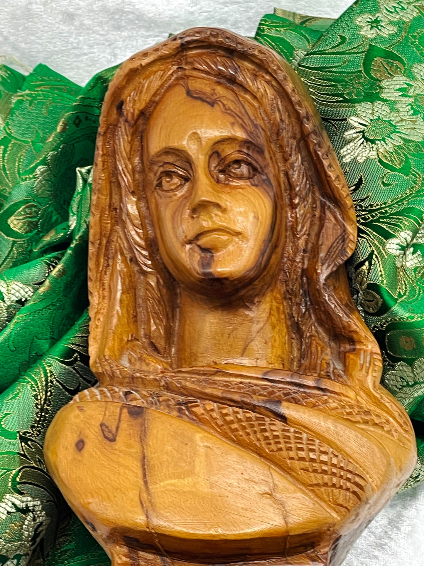 Close detail of the carved face with serene expression and forehead bindi