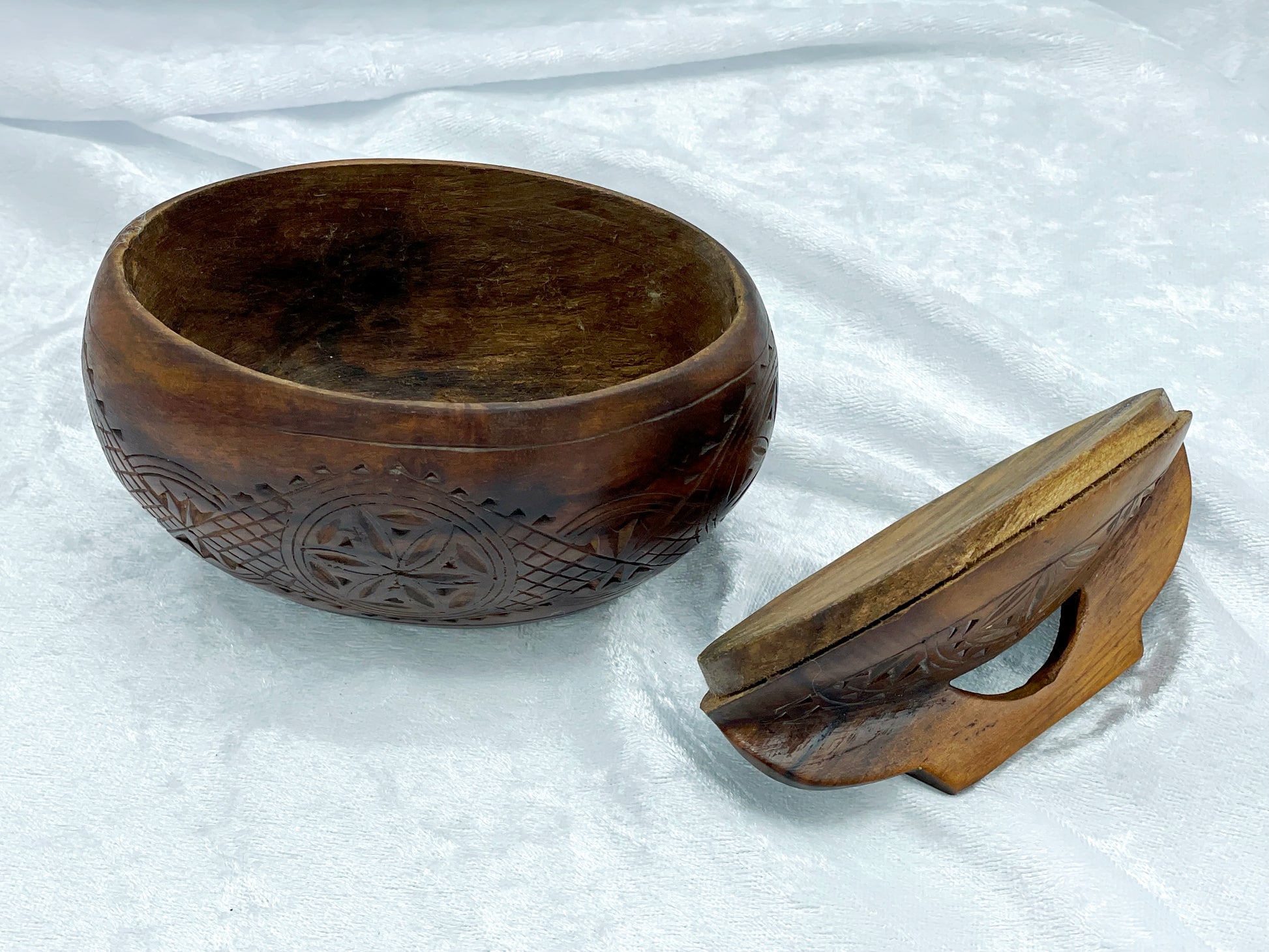 Open carved hardwood box with lid set to the side, showing interior patina and decorative carving