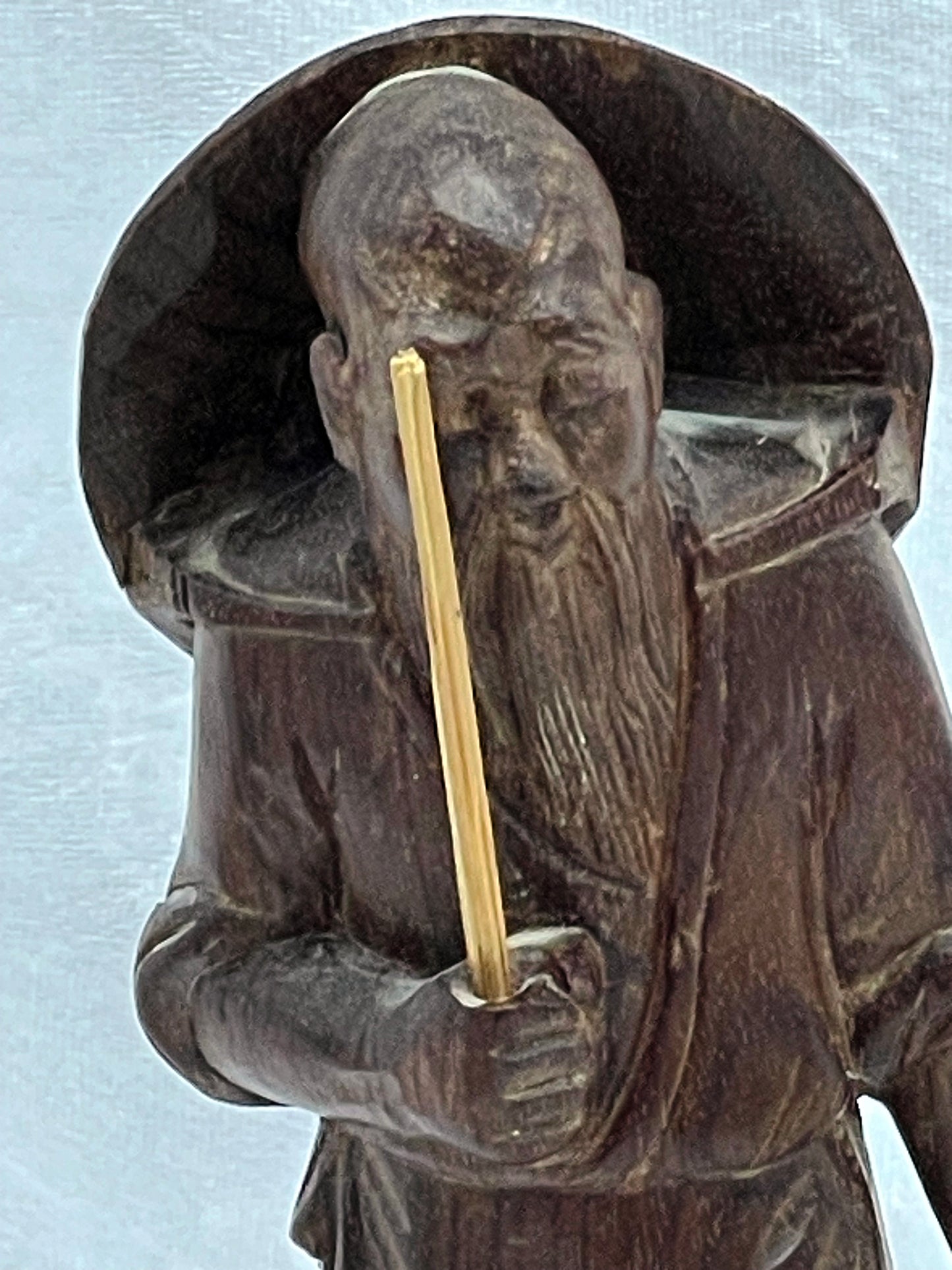 Close-up of the carved face, conical hat and flowing beard of the hardwood sage figure