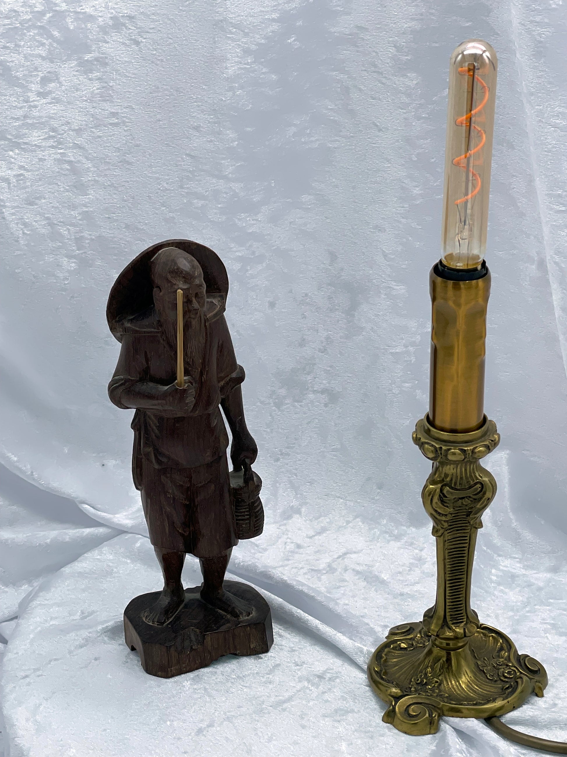 Carved hardwood sage figure shown beside a table lamp for scale on white