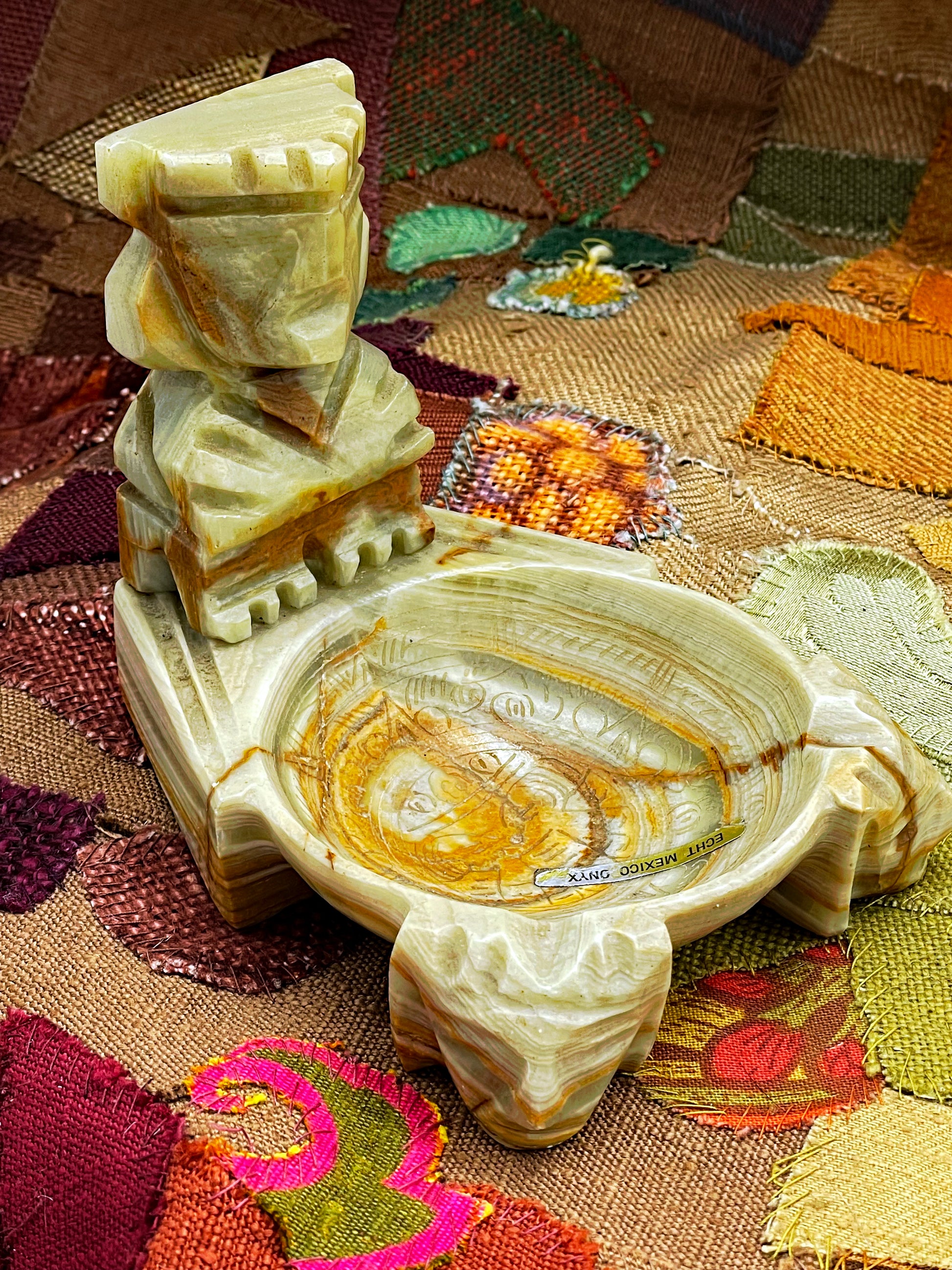 Top-down view of onyx ashtray showing polished banded marble bowl and figure