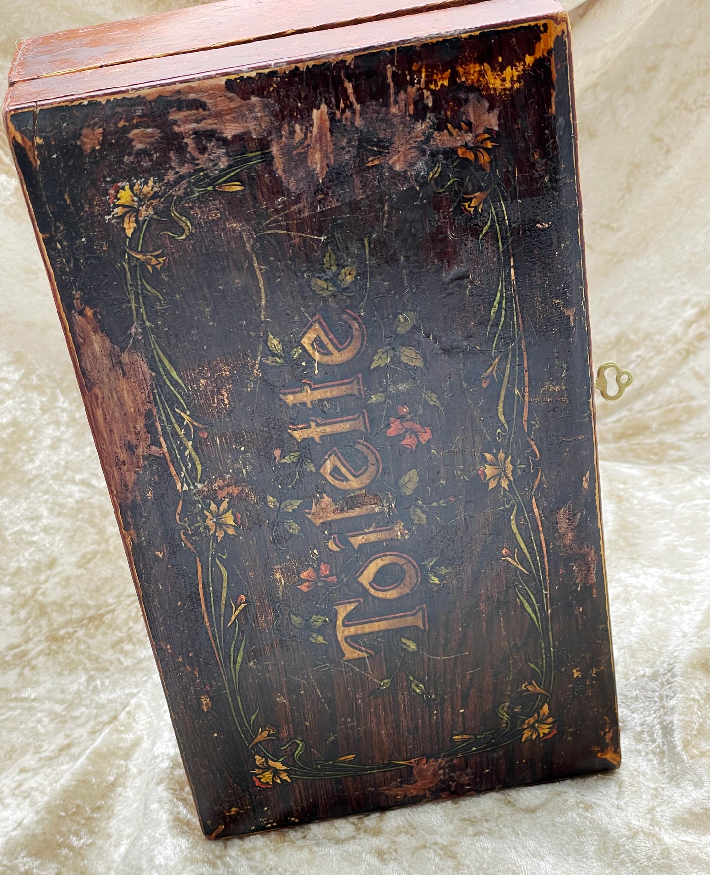 Upright view of French wooden casket lid with gilt Toilette script and flowers