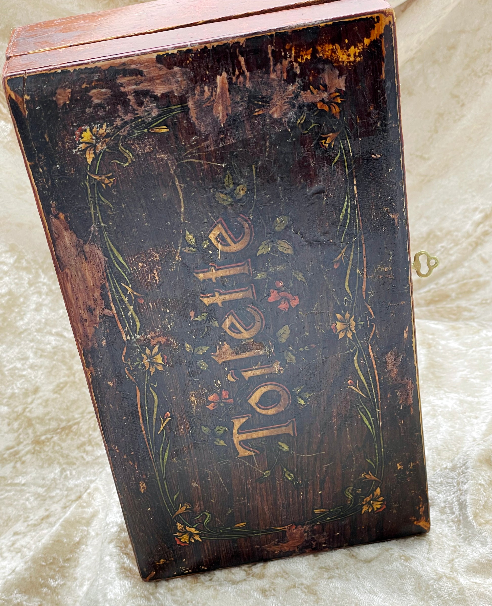 Upright view of French wooden casket lid with gilt Toilette script and flowers