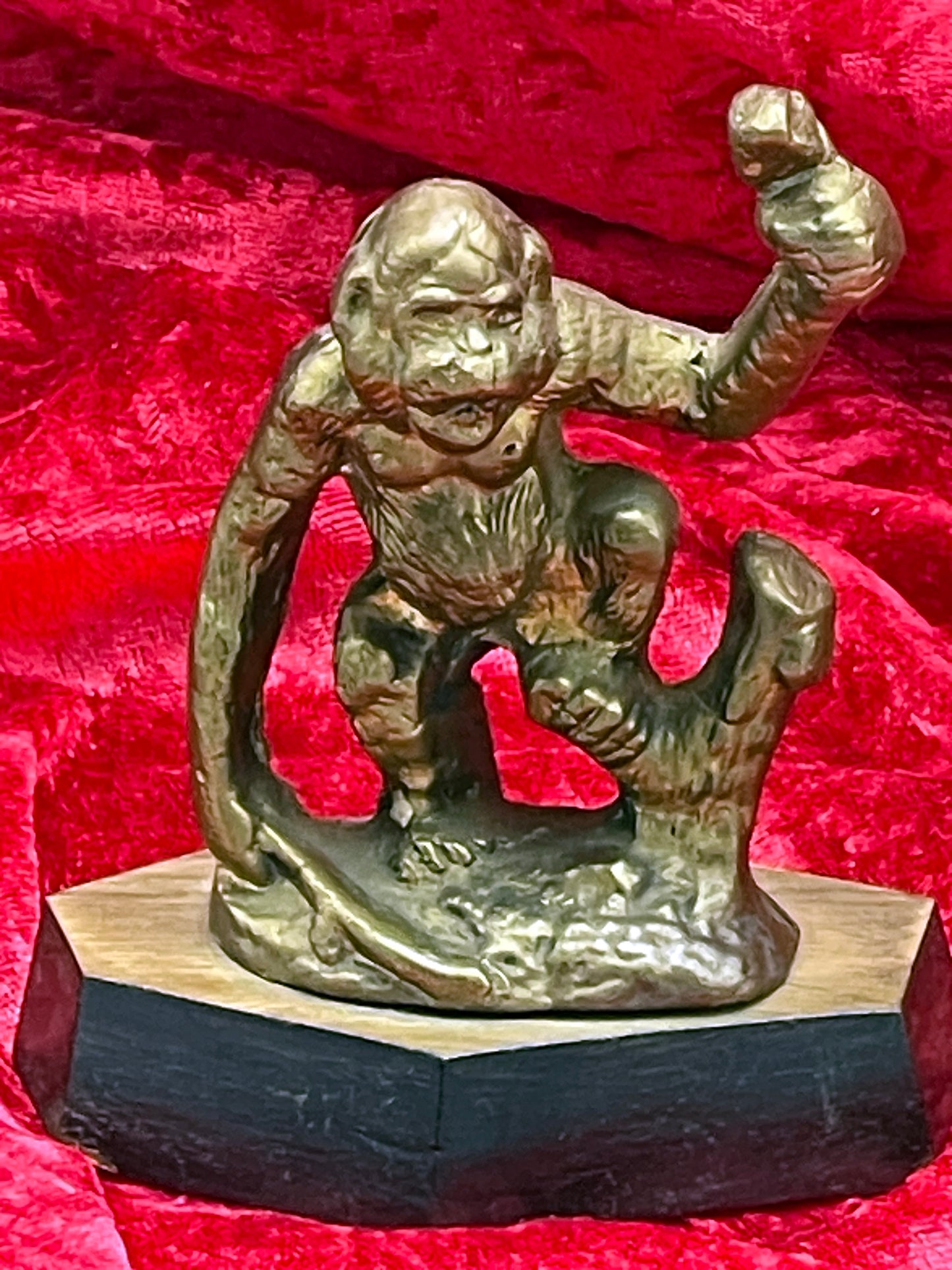 Cast bronze gorilla sculpture front view showing expressive face and raised arm