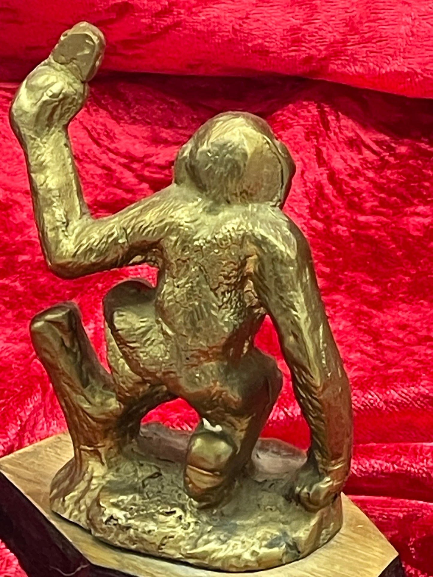 Rear view of vintage bronze ape sculpture showing modelled back on wooden socle