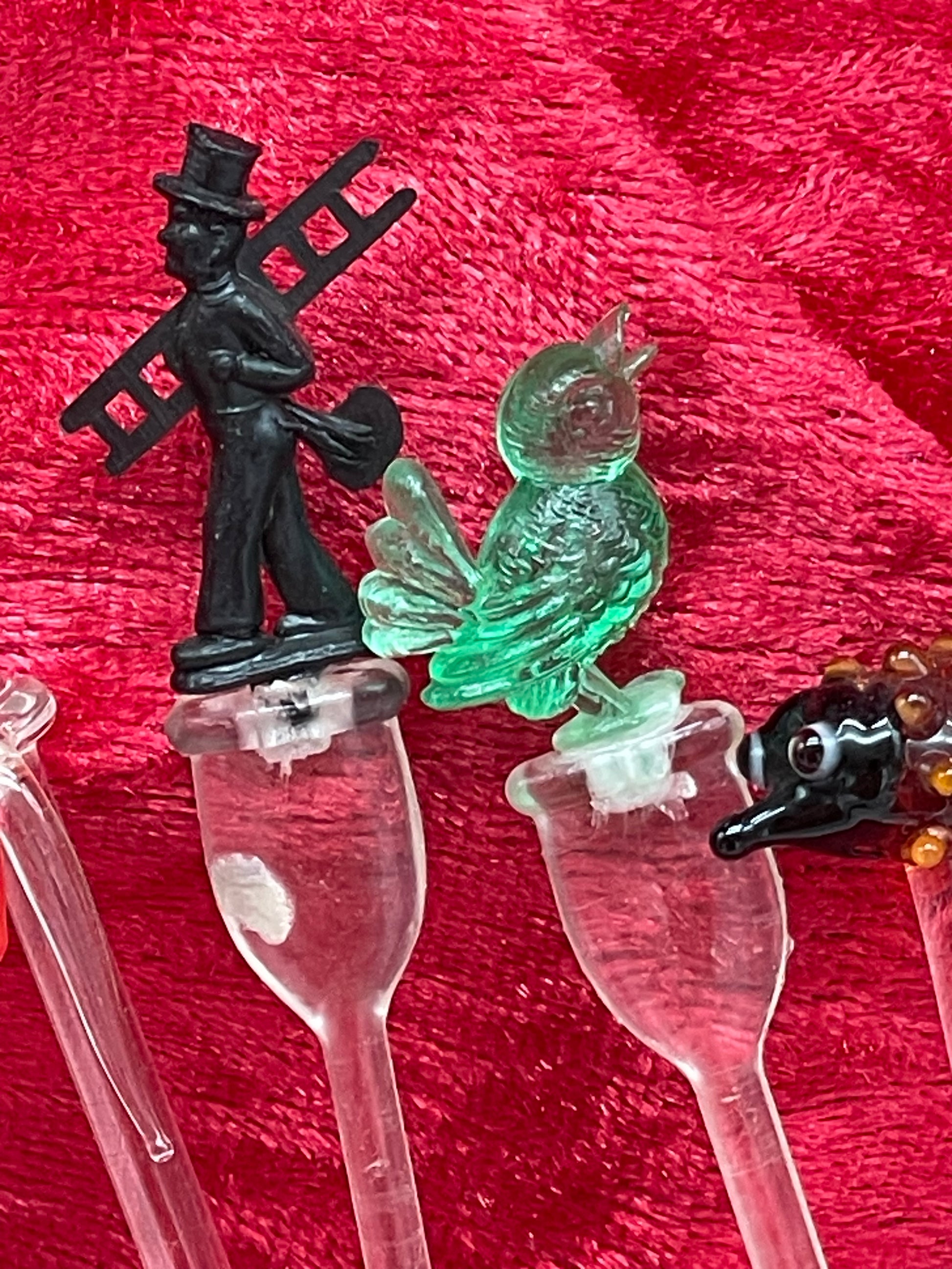 Detail of cast brass leaping gazelle and red glass fish cocktail picks