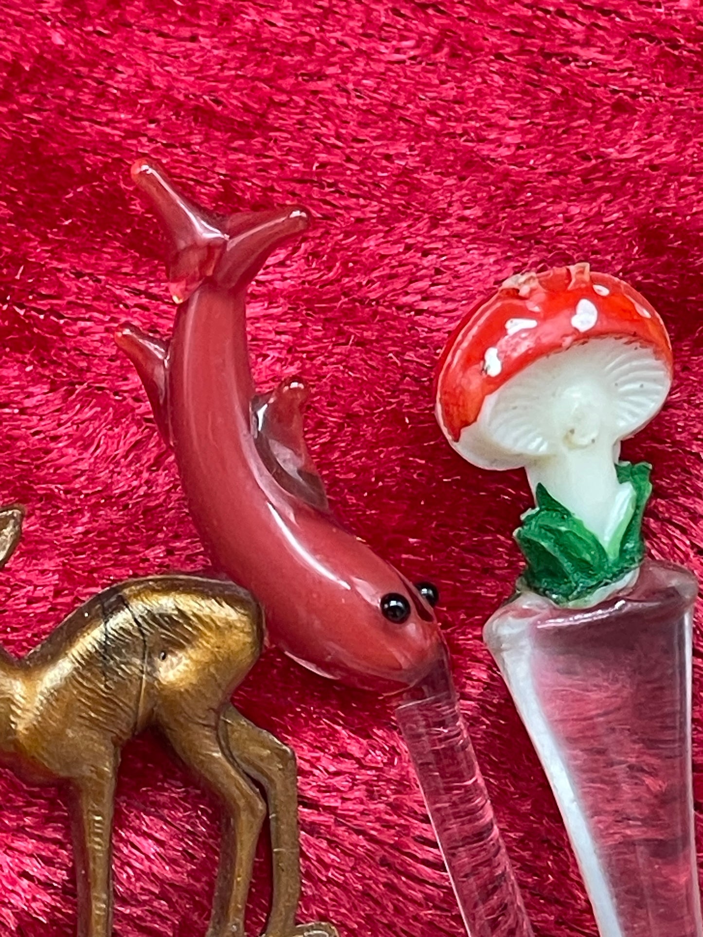 Close-up of blue glass bird, white glass swan and figural cocktail pick toppers
