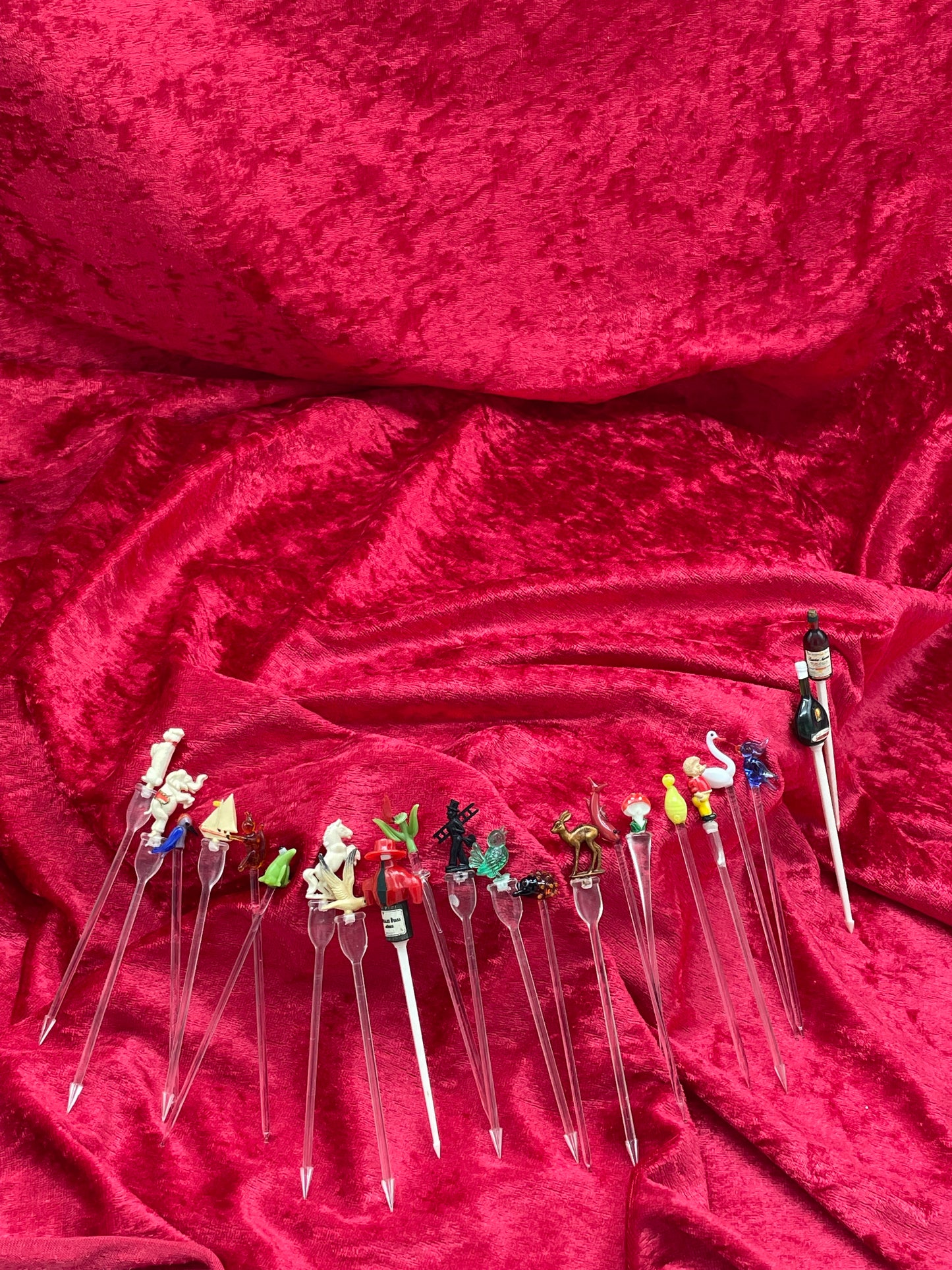 Complete set of mid-century figural cocktail picks laid out, glass stems with character toppers