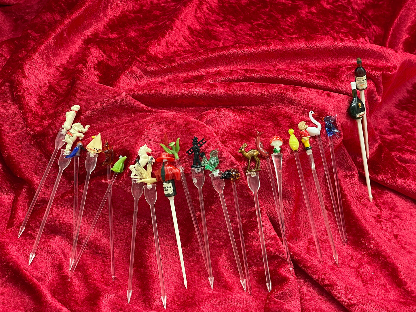 Vintage cocktail picks collection spread in an arc showing all figural swizzle sticks