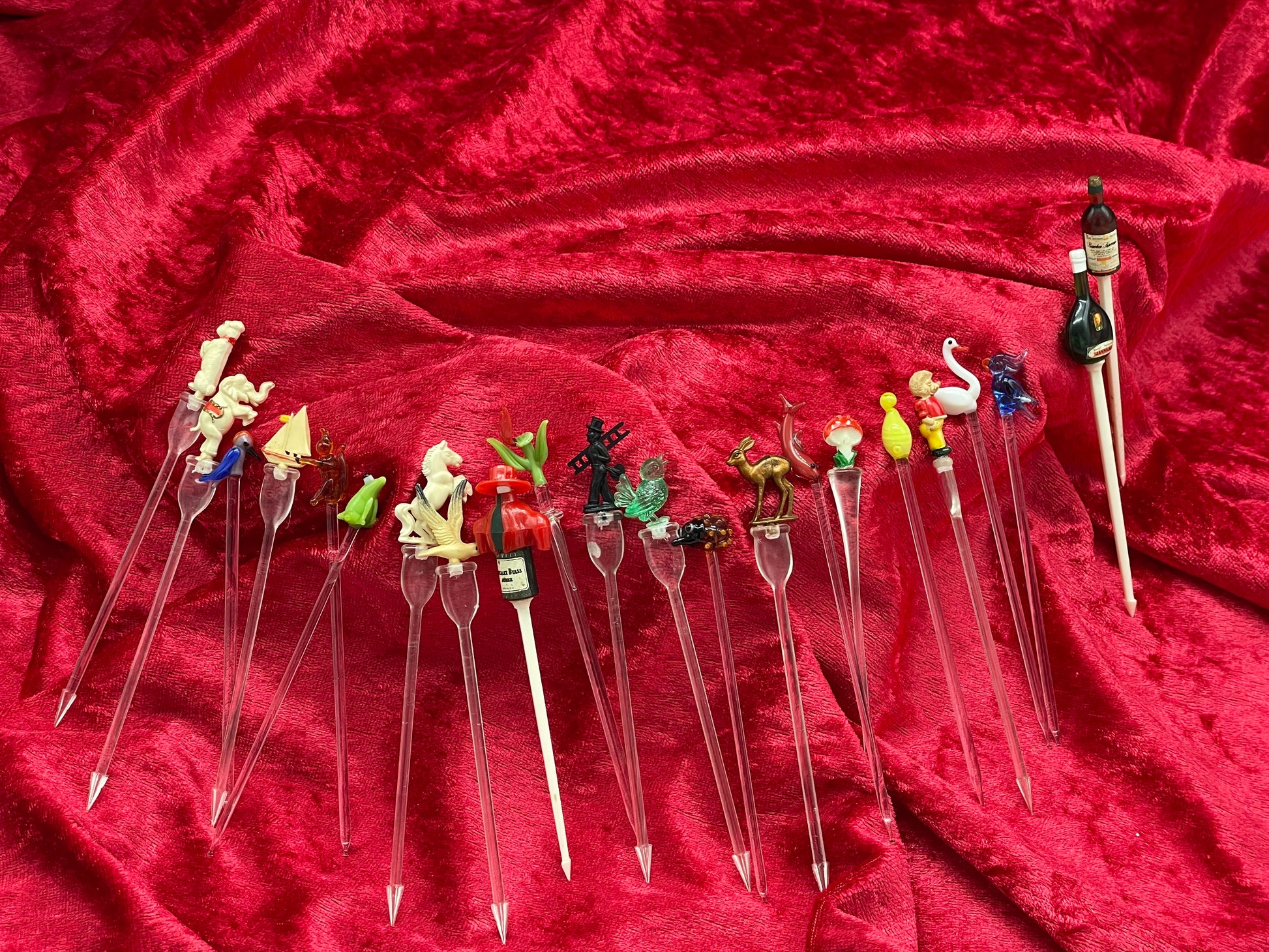 Vintage cocktail picks collection spread in an arc showing all figural swizzle sticks