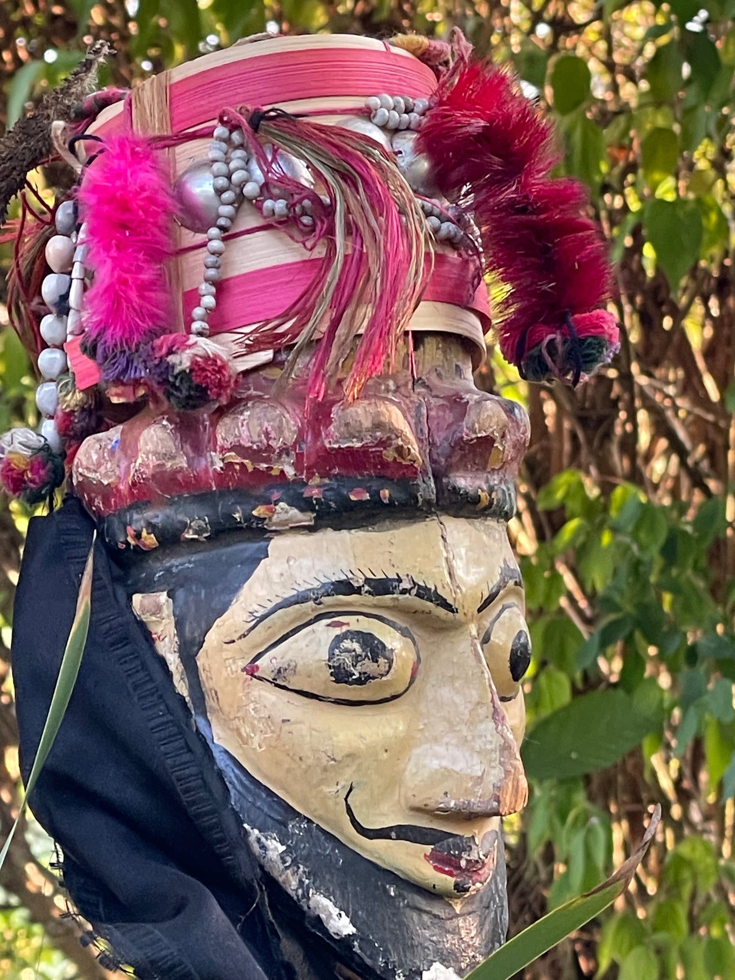 Detail of carved and painted red demon face showing teeth and patina, Java