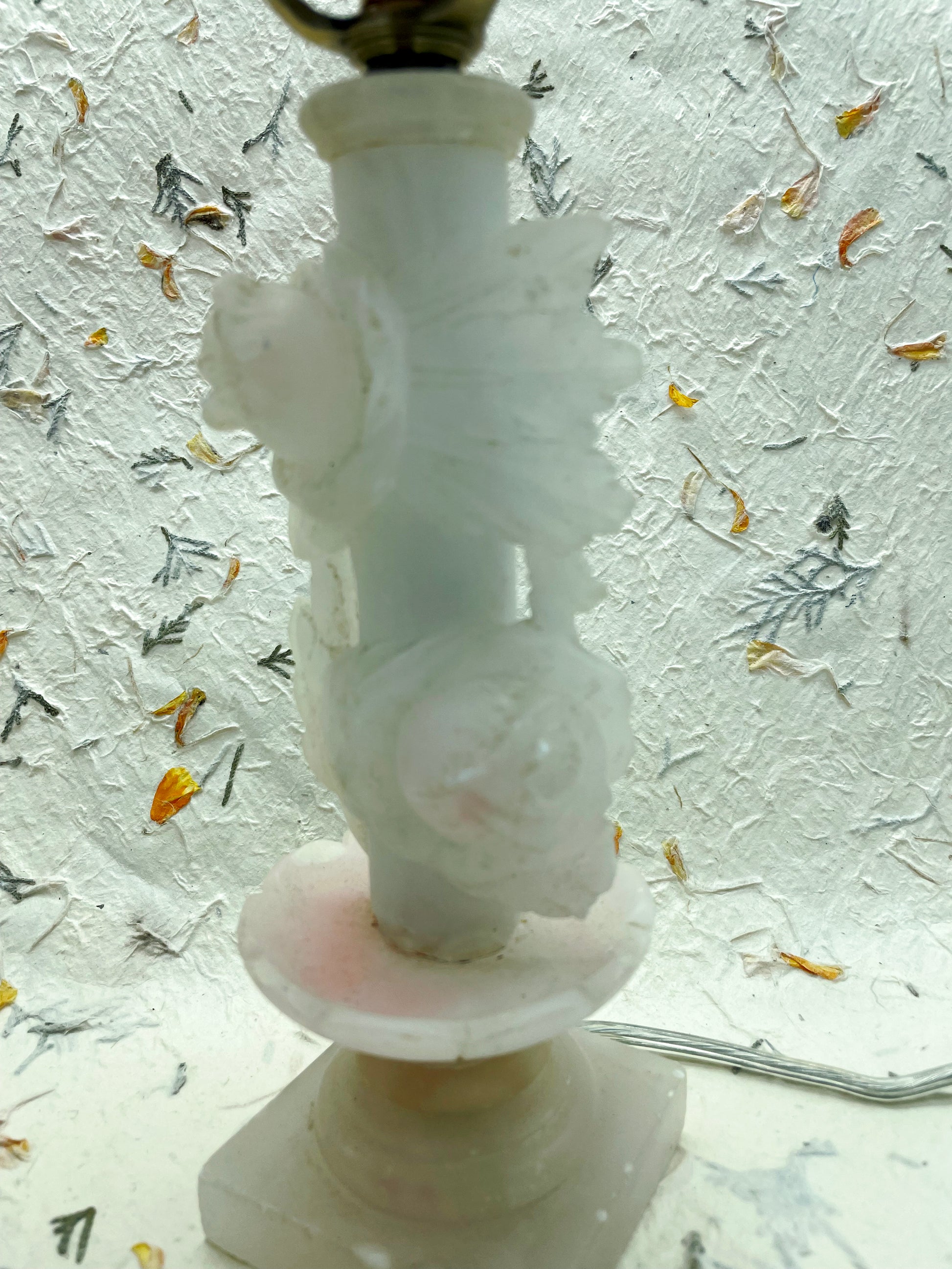 Carved white marble column with sculpted roses