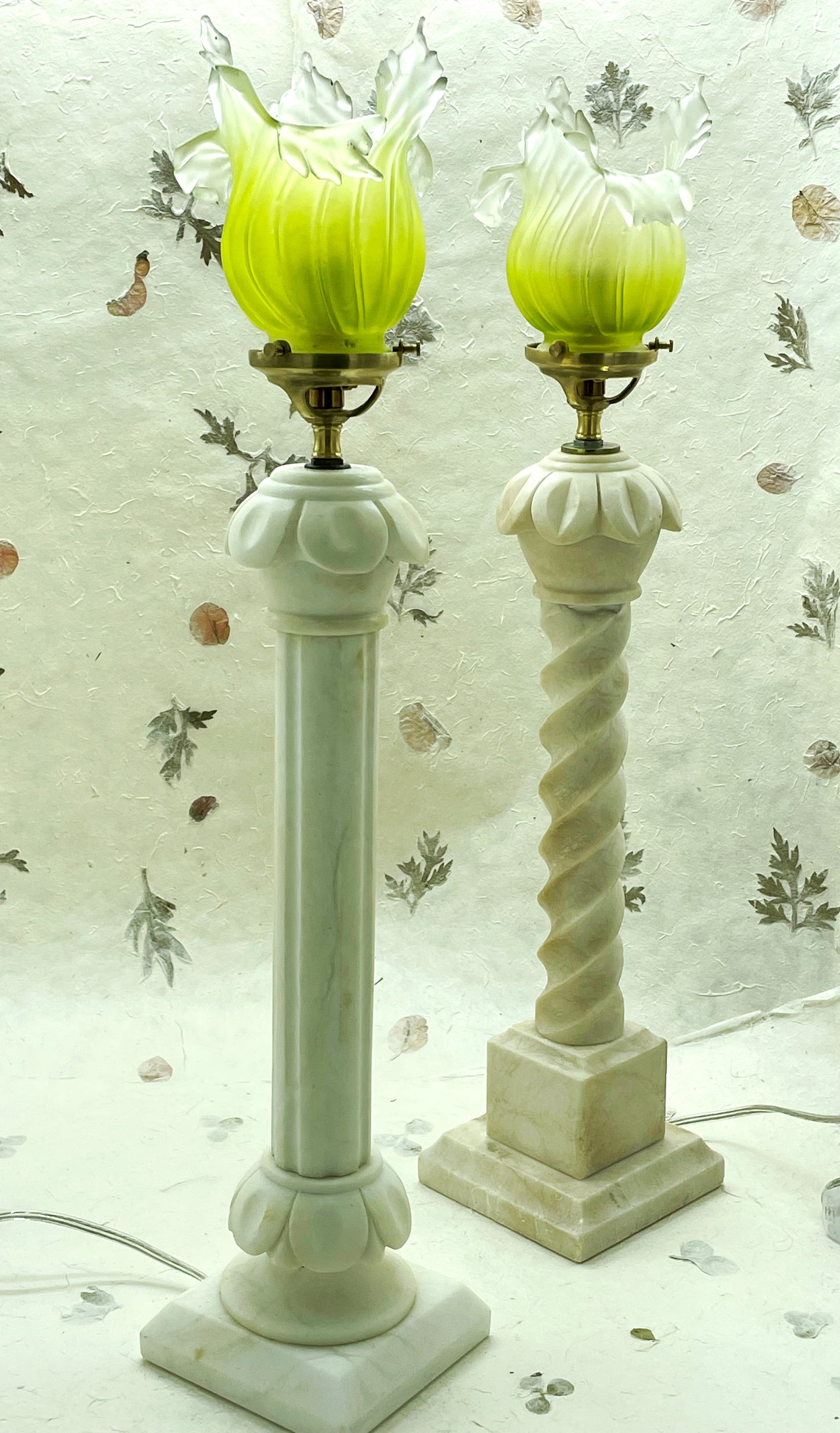 French marble column lamps lit, green glass glowing